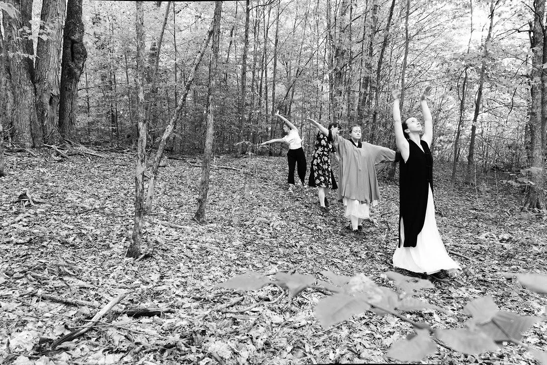 Black and white photo of 4 dancers in a northern forest