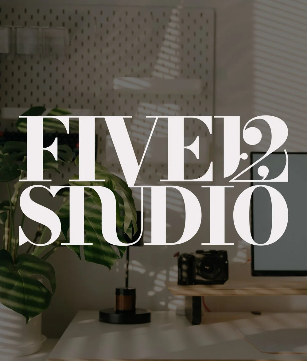 A modern workspace with a desk, computer monitor, camera, and a potted plant, with the text FIVE12 STUDIO' overlayed.