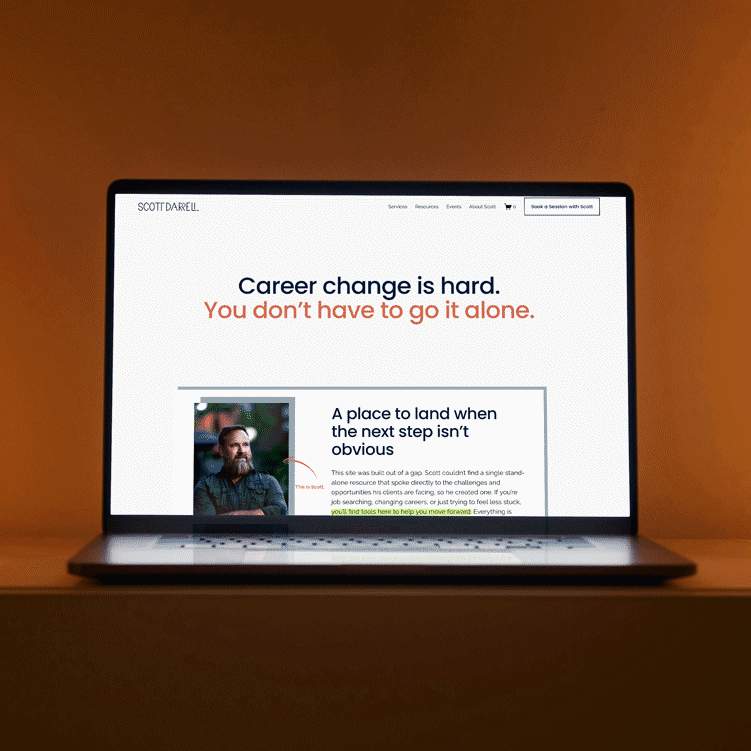 Laptop screen displaying a career coaching website with the headline 'Career change is hard. You don't have to go it alone.' and an image of a bearded man.