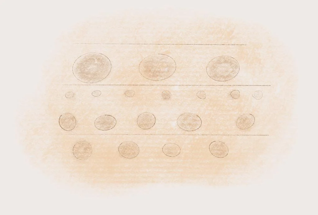 A faint, hand-drawn diagram on a piece of paper showing various circles arranged in rows, with some circles shaded or filled in.