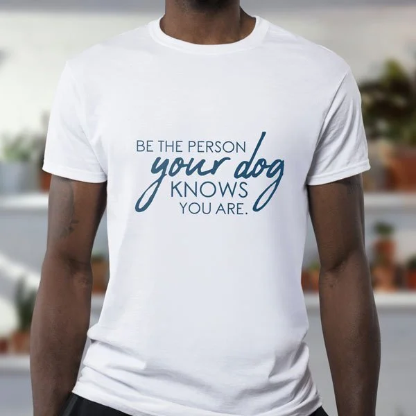 White T-shirt with the quote 'Be the person your dog knows you are' in blue text.