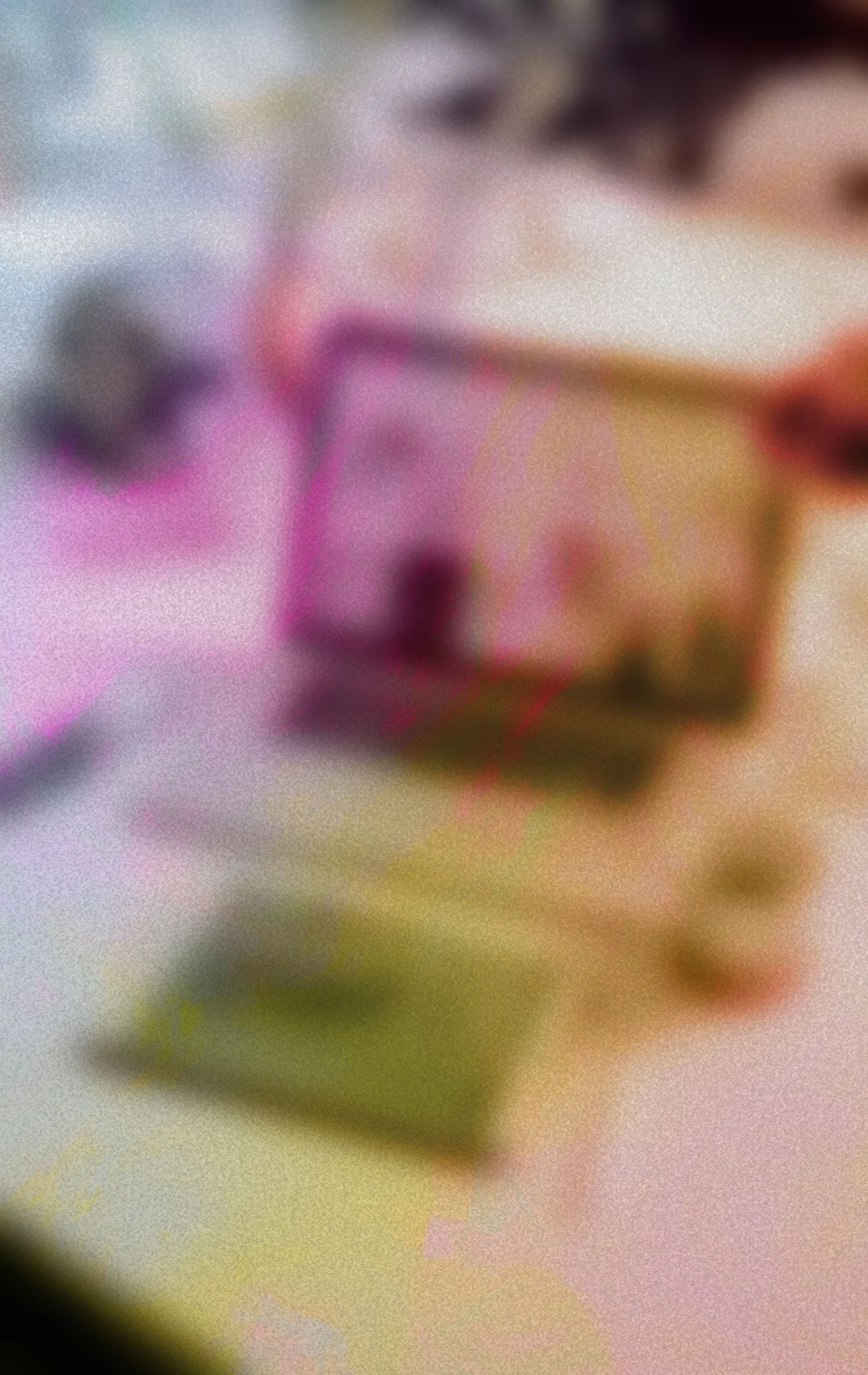 Close-up of a blurred stack of books with a person's hand holding a book, a blurred face, and colorful background.
