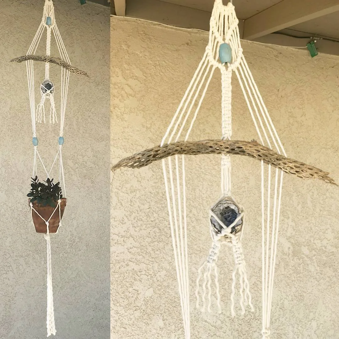 Macrame hanging planter with a potted plant, a cholla skeleton woven into it, and a small geode inside a macrame holder.