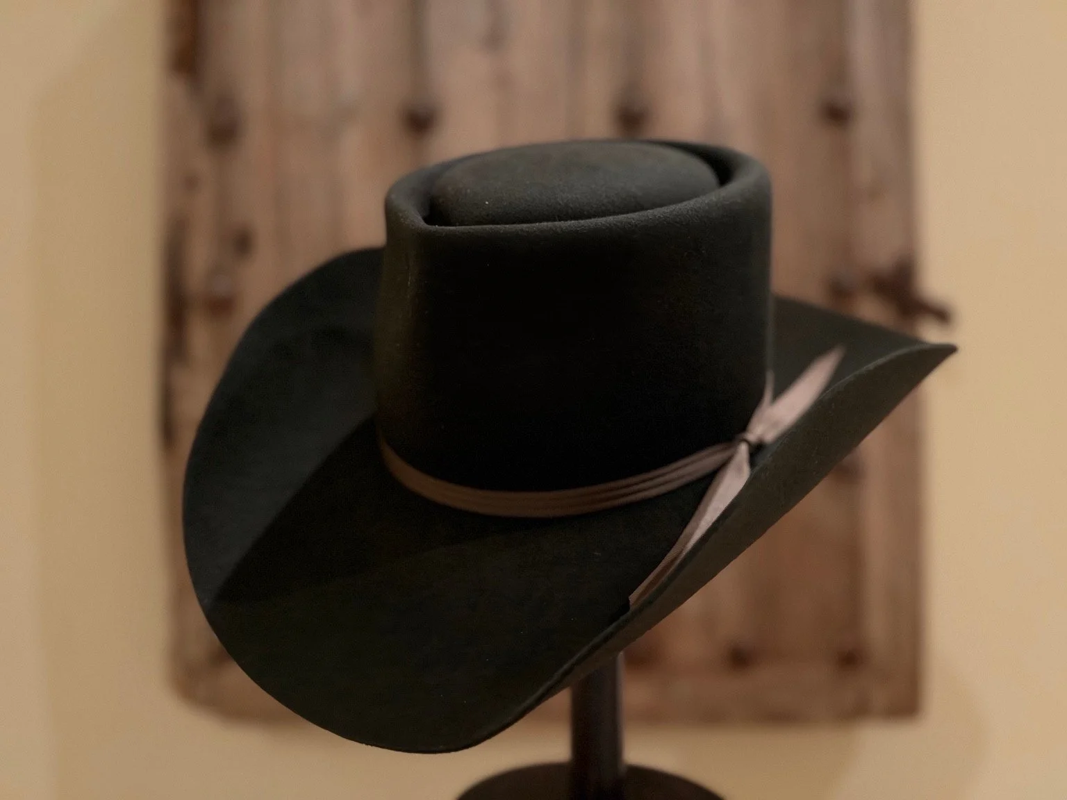 Three-quarter view of Der Nachtwächter showing its broad upturned brim and trailing brown ribbon ends.
