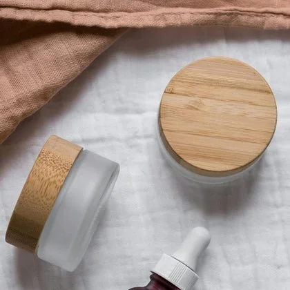 glass tubs with wooden lids posted on a cloth material
