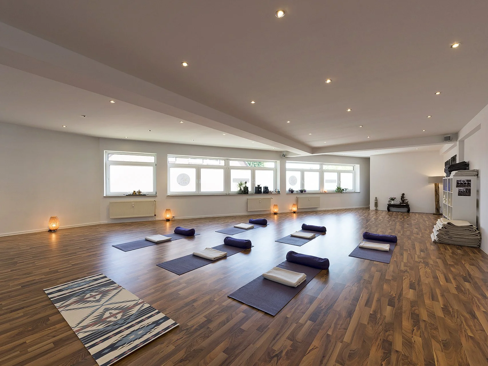 Interior hallway with motivational quote on wall, framed pictures, wooden floor, and open doorway.