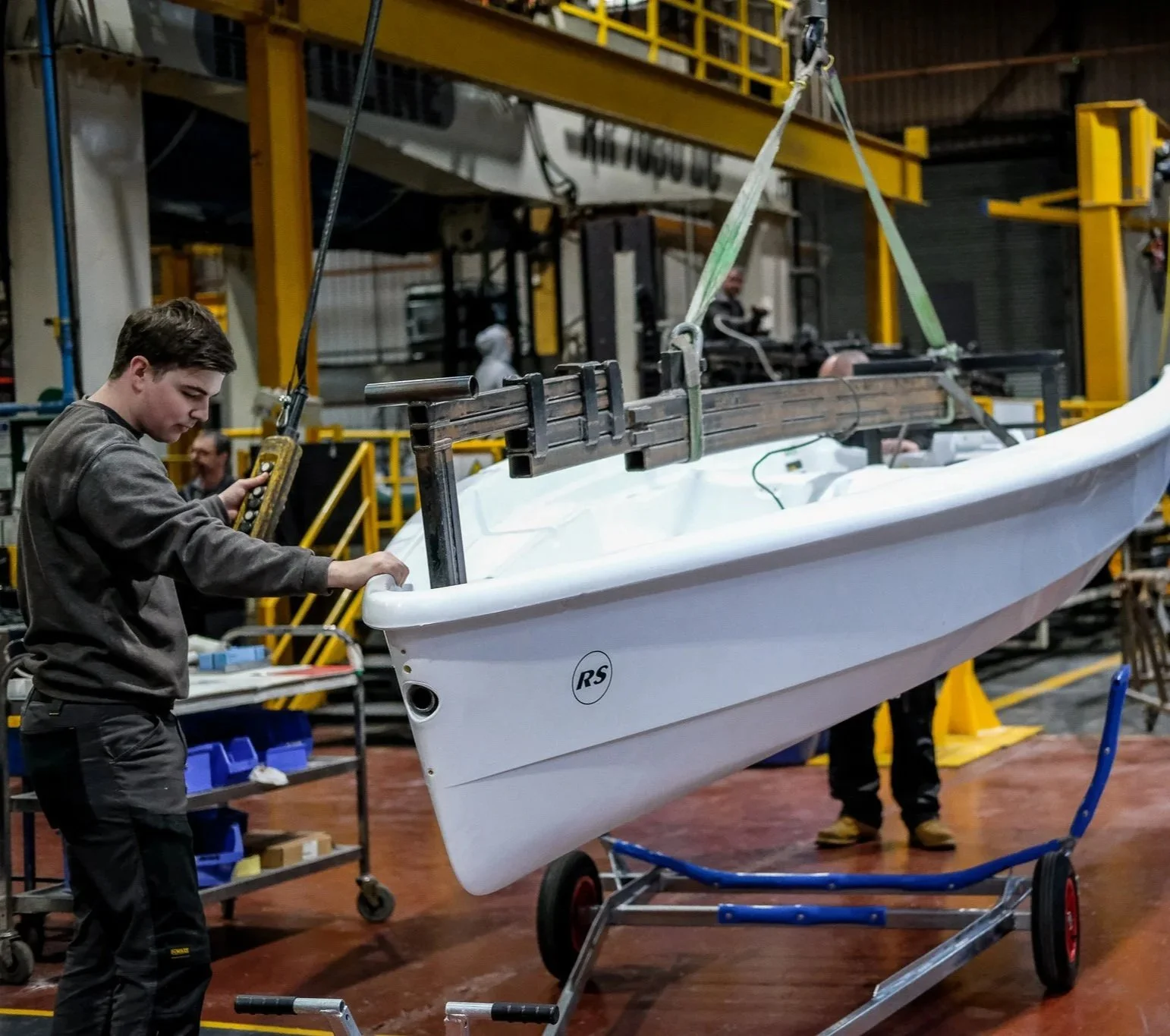 Large green and black machine enclosed in a clear protective casing inside an industrial warehouse. This is the Persico SMART Machine.