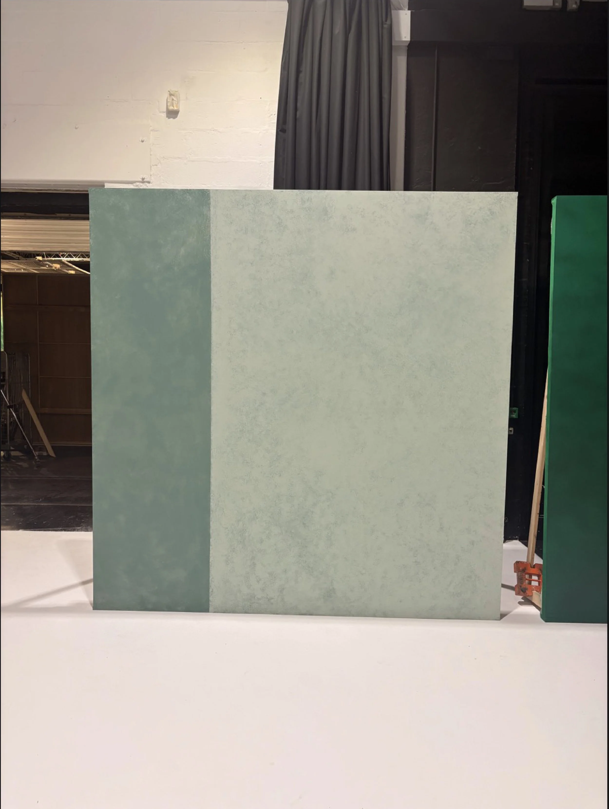 Custom scenic finish applied to fabricated wall structures, developed to achieve a refined stone-like appearance for the final set.