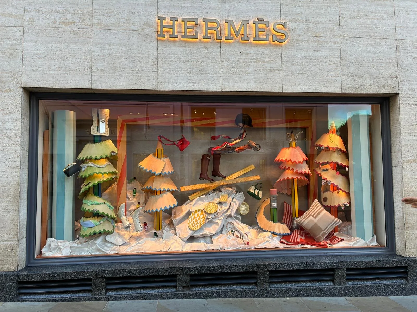 2nd images of the bespoke Christmas window installation for Hermès, designed by Shona Heath and built by Andy Knight, including oversized wooden pencil trees and wood veneer pencil shavings with washed paint effect.  The window landscape is sculpted 