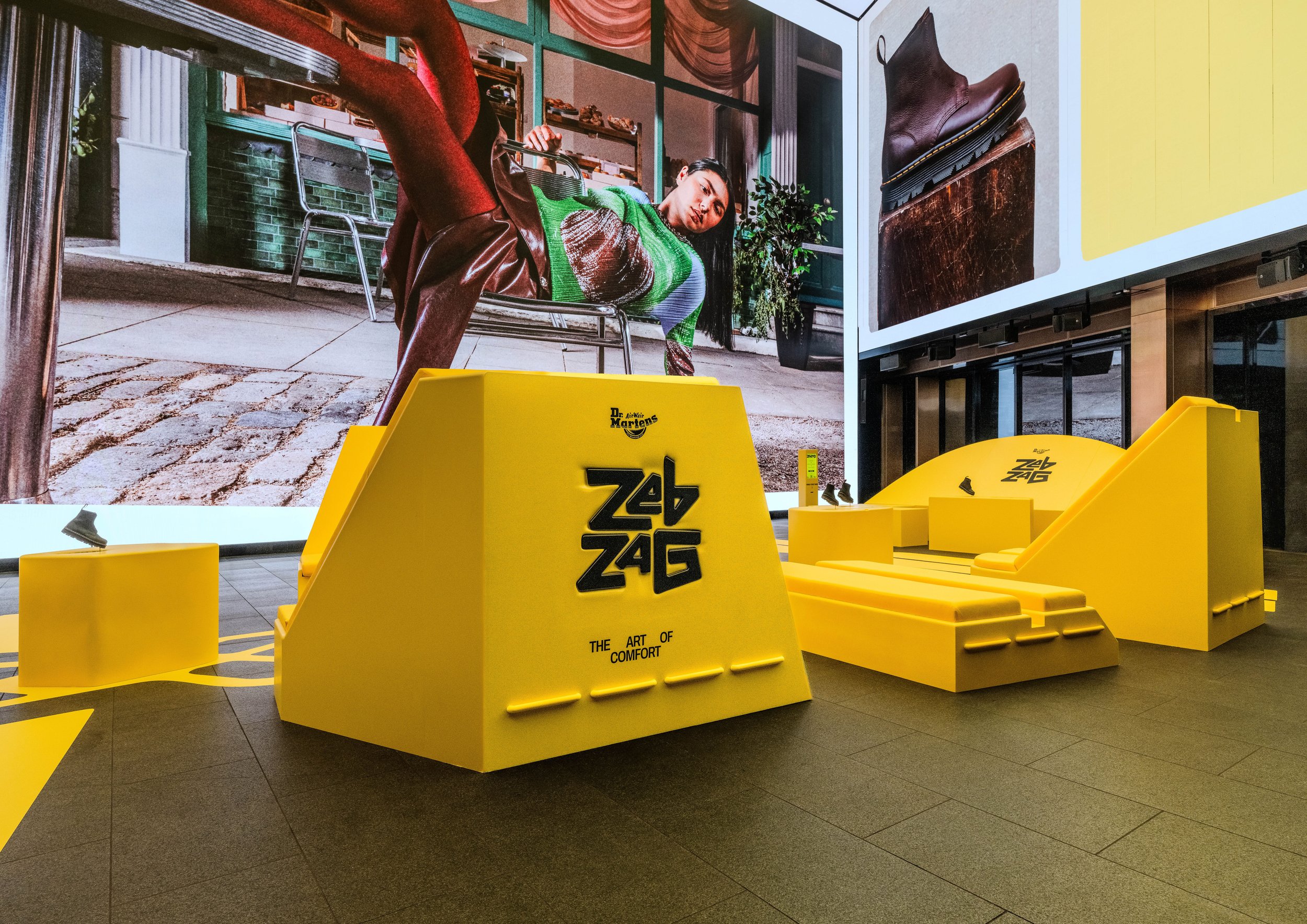 Image of the custom seating Andy Knight constructed from wood with upholstered cushions.  On the back is a Embossed logo and mock stitching 