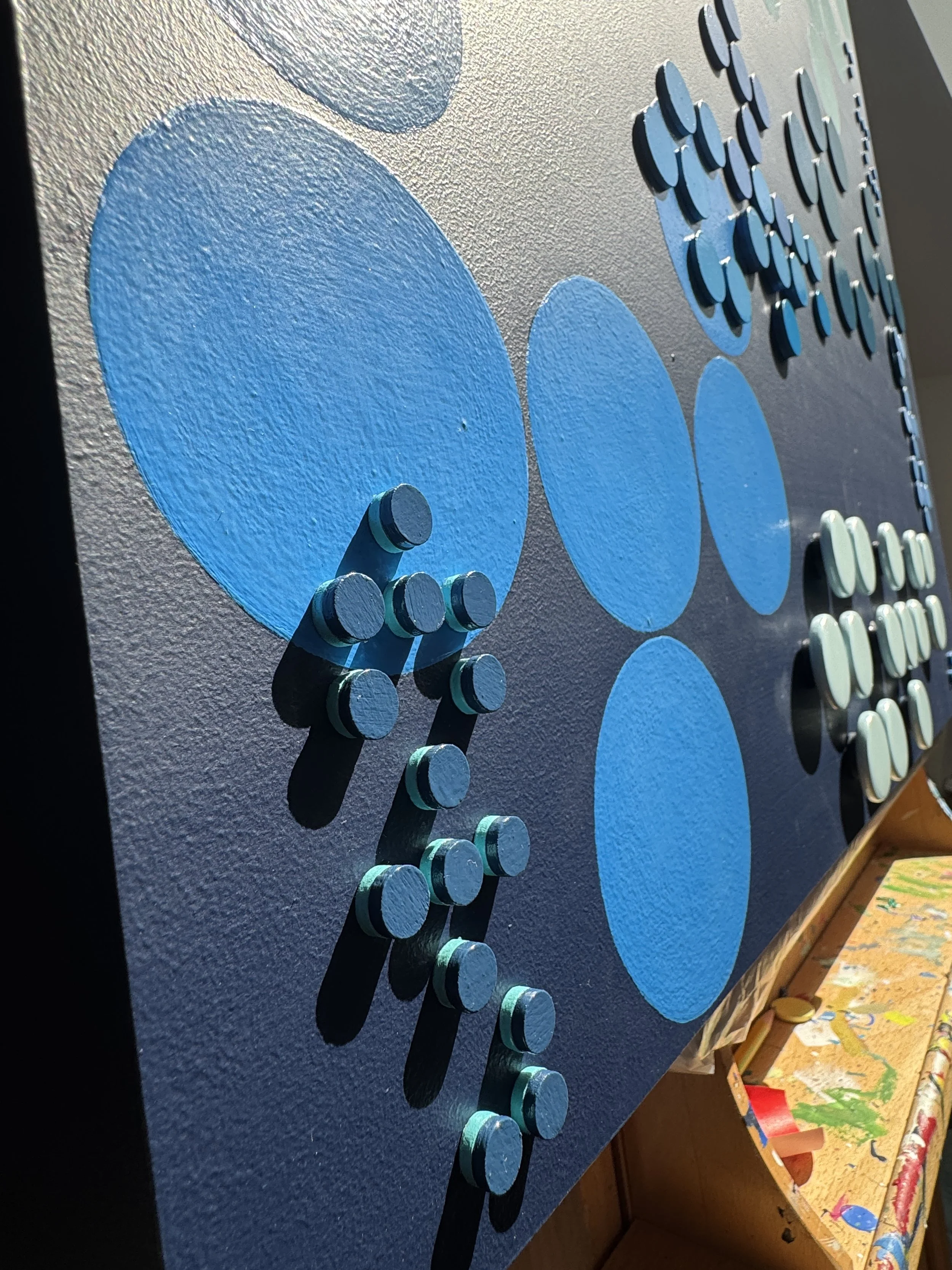 A contemporary abstract Braille artwork exploring the power and repetition of language through layered geometric forms in varying shades of blue. Repeating the word “WORD” in Braille, the piece examines how language overlaps, rises, fades, and shapes