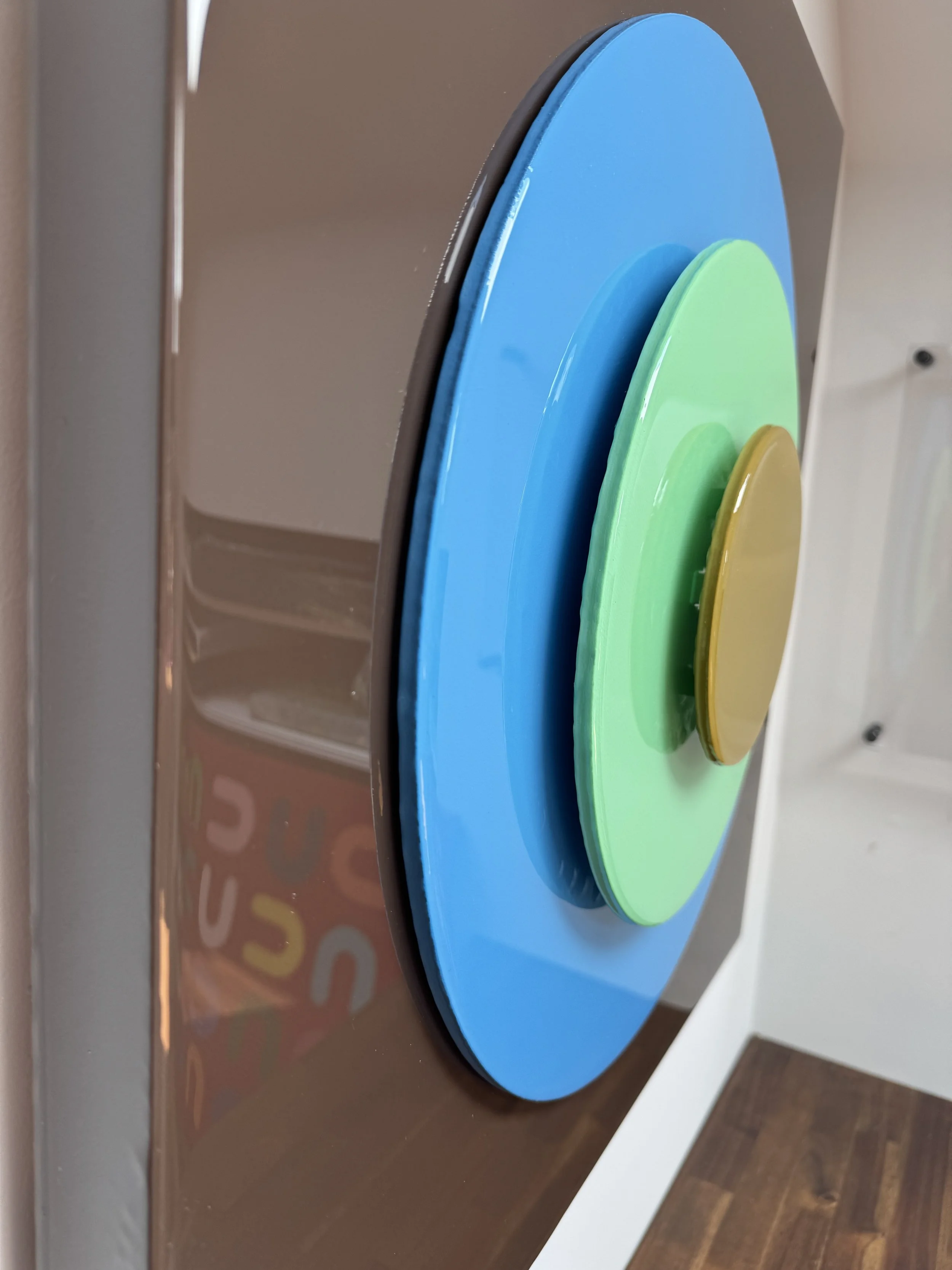 This custom Taking Aim installation for a Charlotte, NC home combines bold geometric simplicity with layered 3D construction and high-gloss resin finishes. The dimensional bullseye composition creates shifting reflections, depth, and shadow throughou