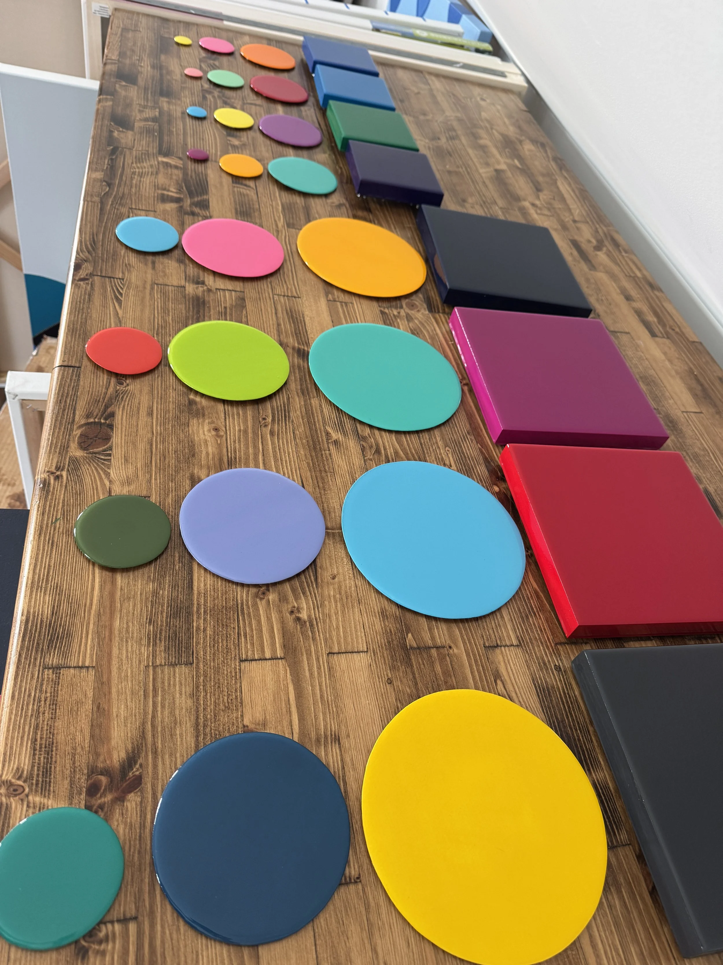 These small-scale Taking Aim pieces combine bold geometric compositions with layered dimensional elements and high-gloss resin surfaces. Exploring focus, direction, and personal momentum, each work uses vibrant color relationships and reflective fini