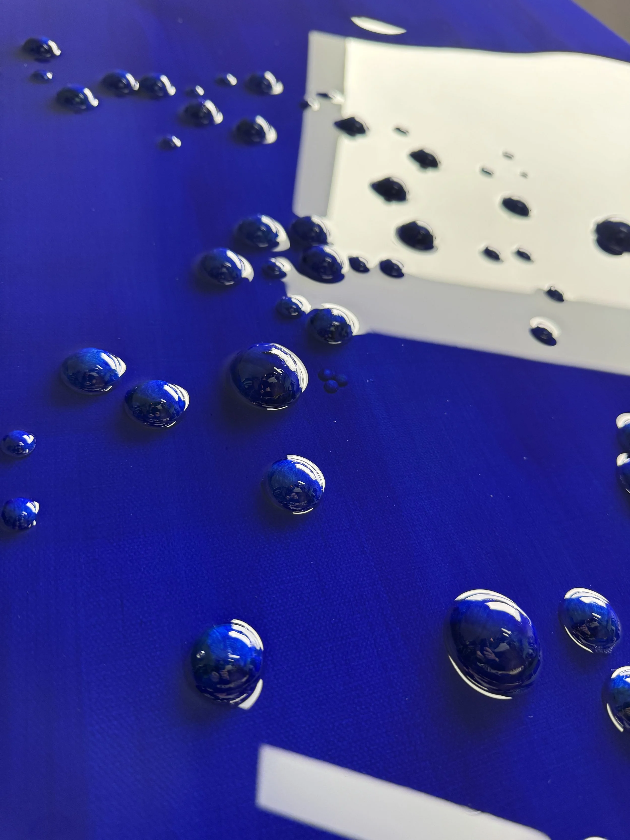 Ultramarine blue abstract artwork with raised Braille-inspired forms and glossy resin surface by Merrill Moore