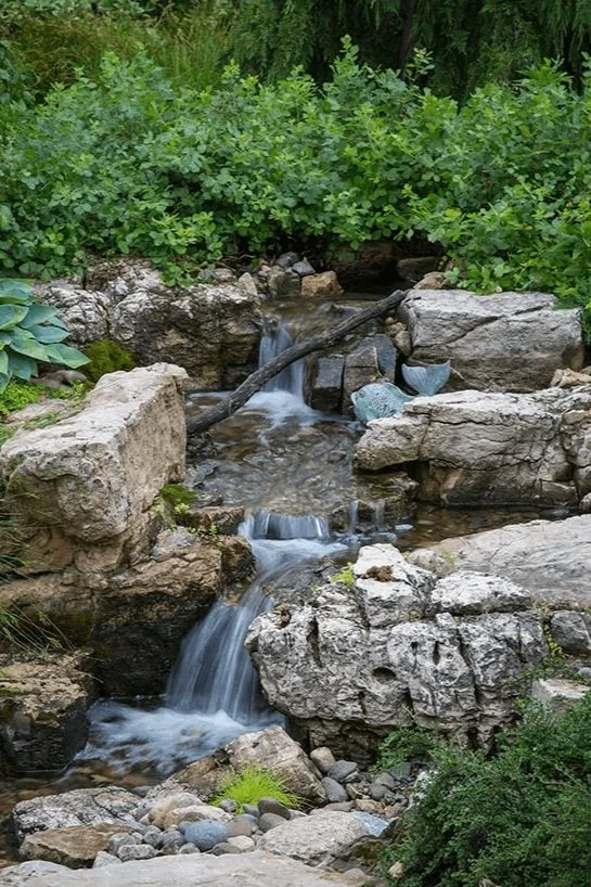 large pondless waterfall meandering through yard