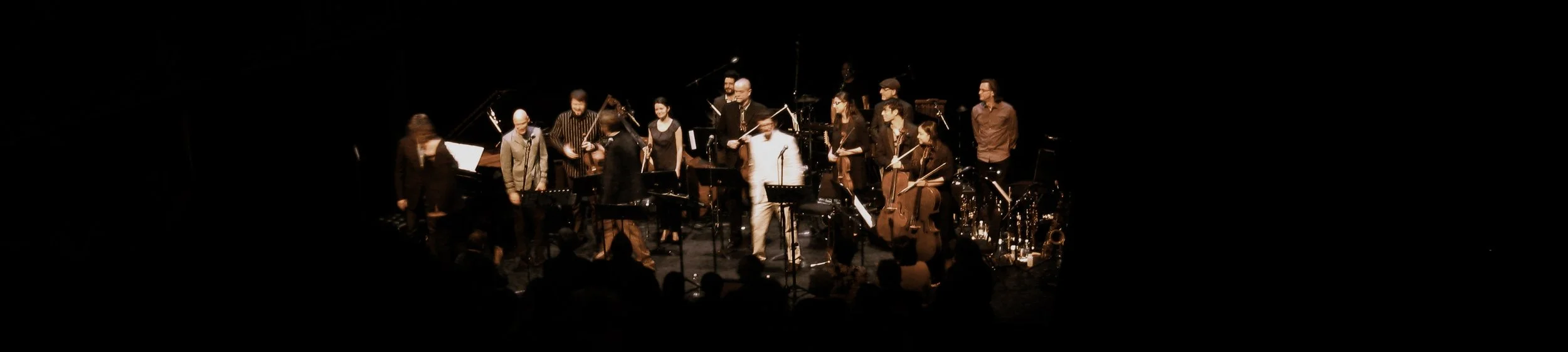  From left to right: Andrew Burashko, John Mann, Stephen Sitarski, Steven Page, Veronique Mathieu, Joseph Phillips, Douglas Perry, Andy Maize, Rick Sacks, Carolyn Blackwell, Rob Piltch, Alastair Eng, Rachel Mercer, Larry Larson 