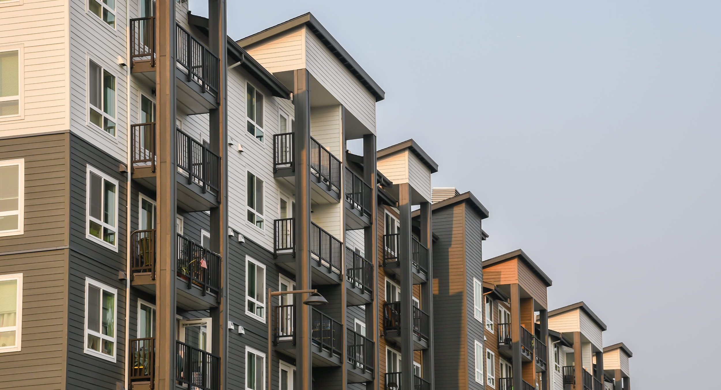 Property manager holding a tablet outside an apartment building