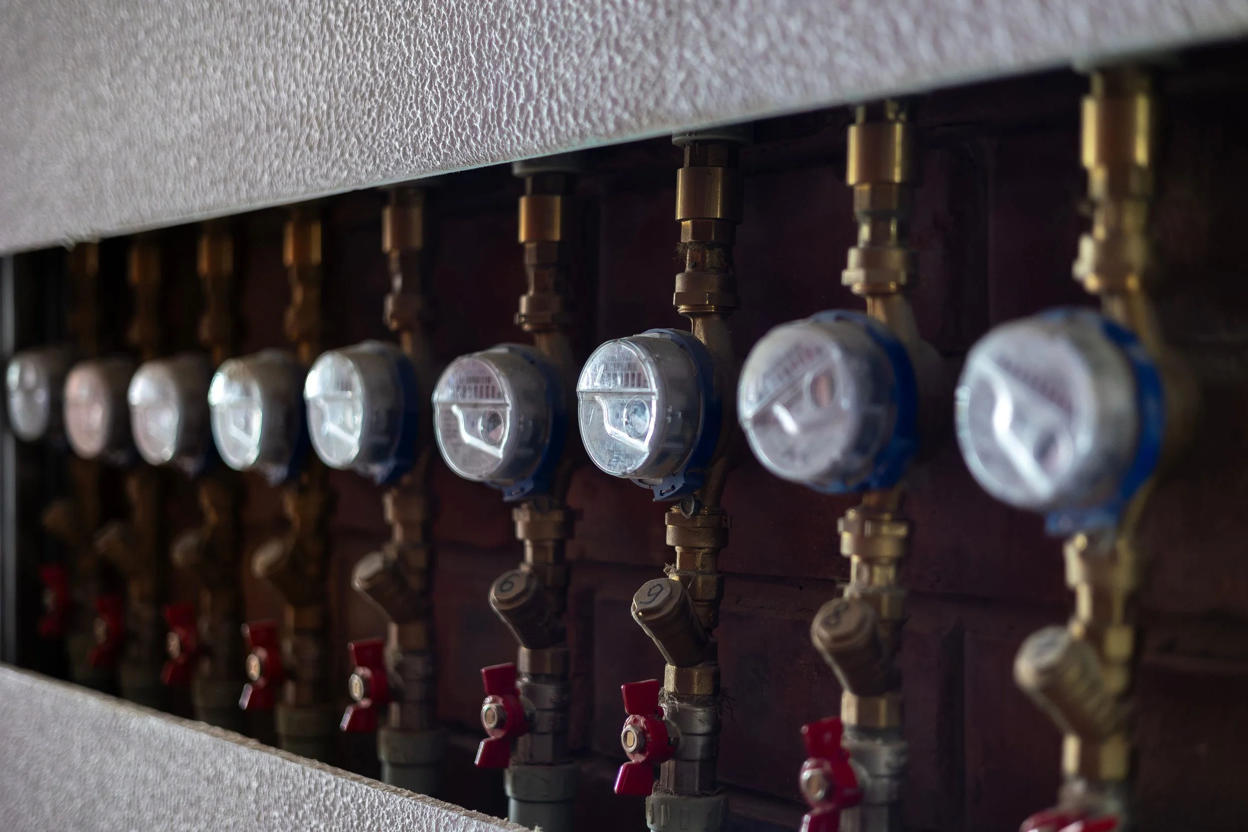 Row of installed water submeters mounted on a pipe system for a multifamily property