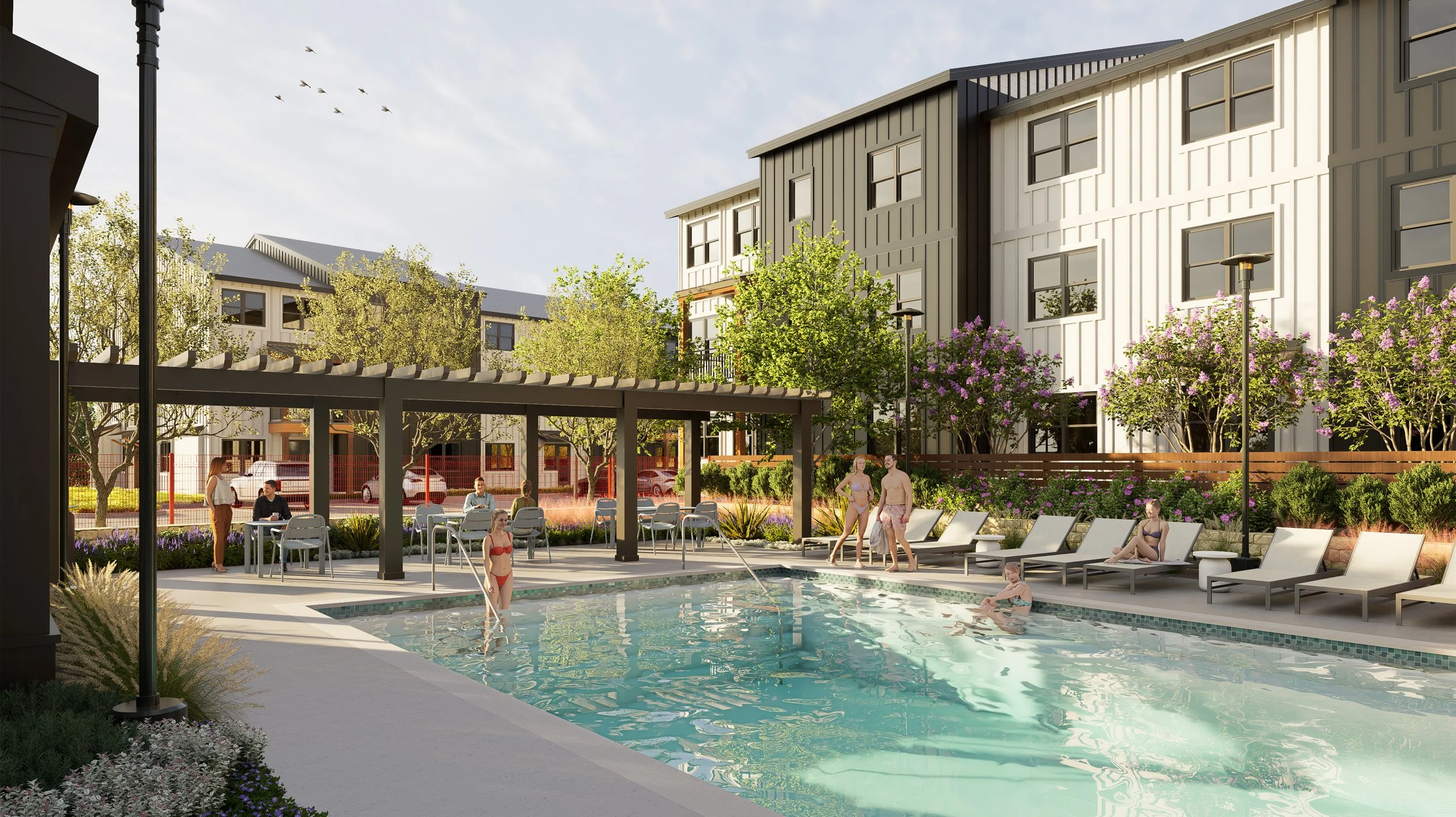 Residential pool area with people swimming, relaxing on lounge chairs, and socializing under a shaded structure, surrounded by trees and modern apartment buildings.