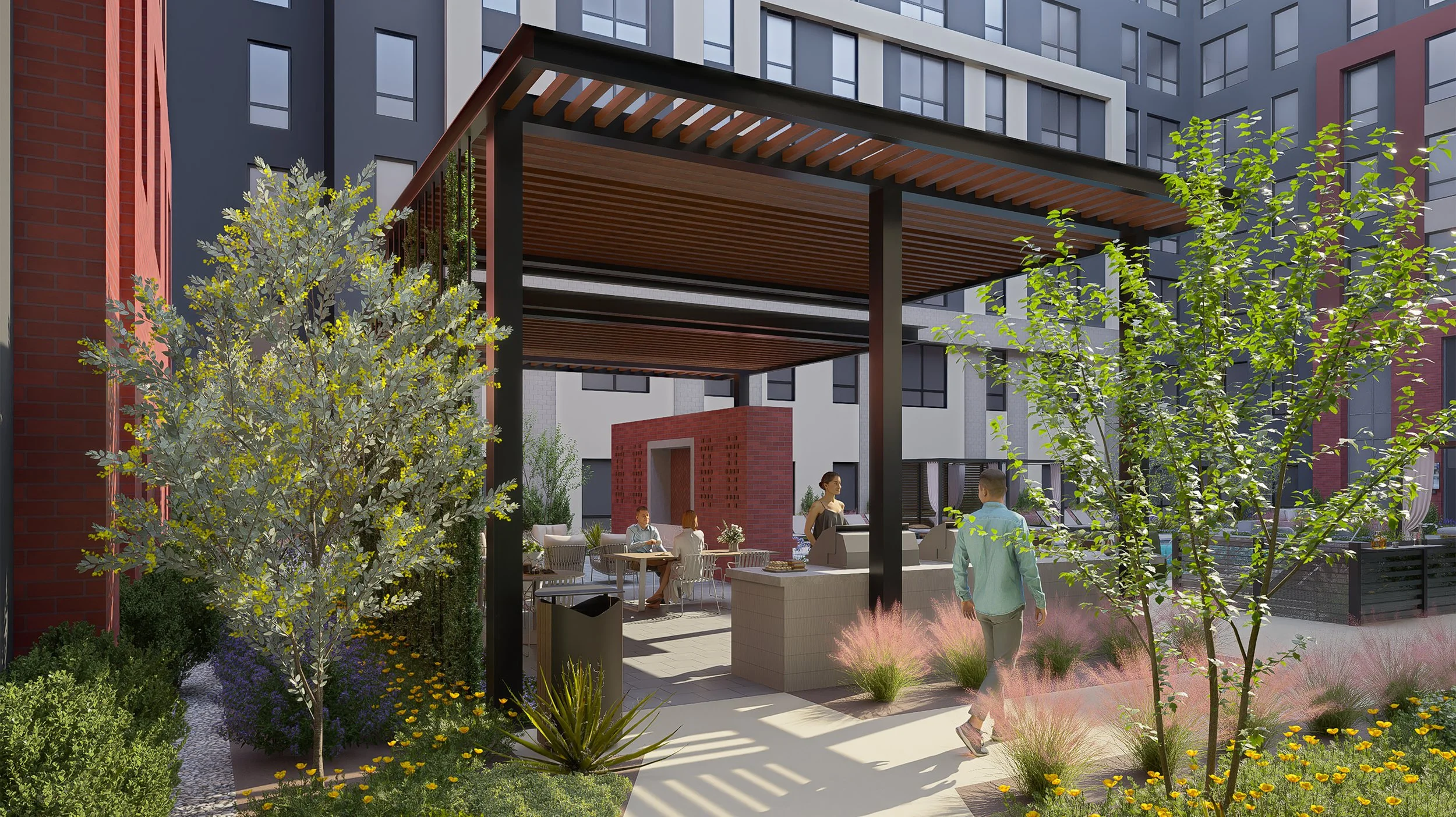 Outdoor patio area with people sitting and standing, surrounded by trees and colorful plants, in front of modern apartment buildings with a pergola overhead.
