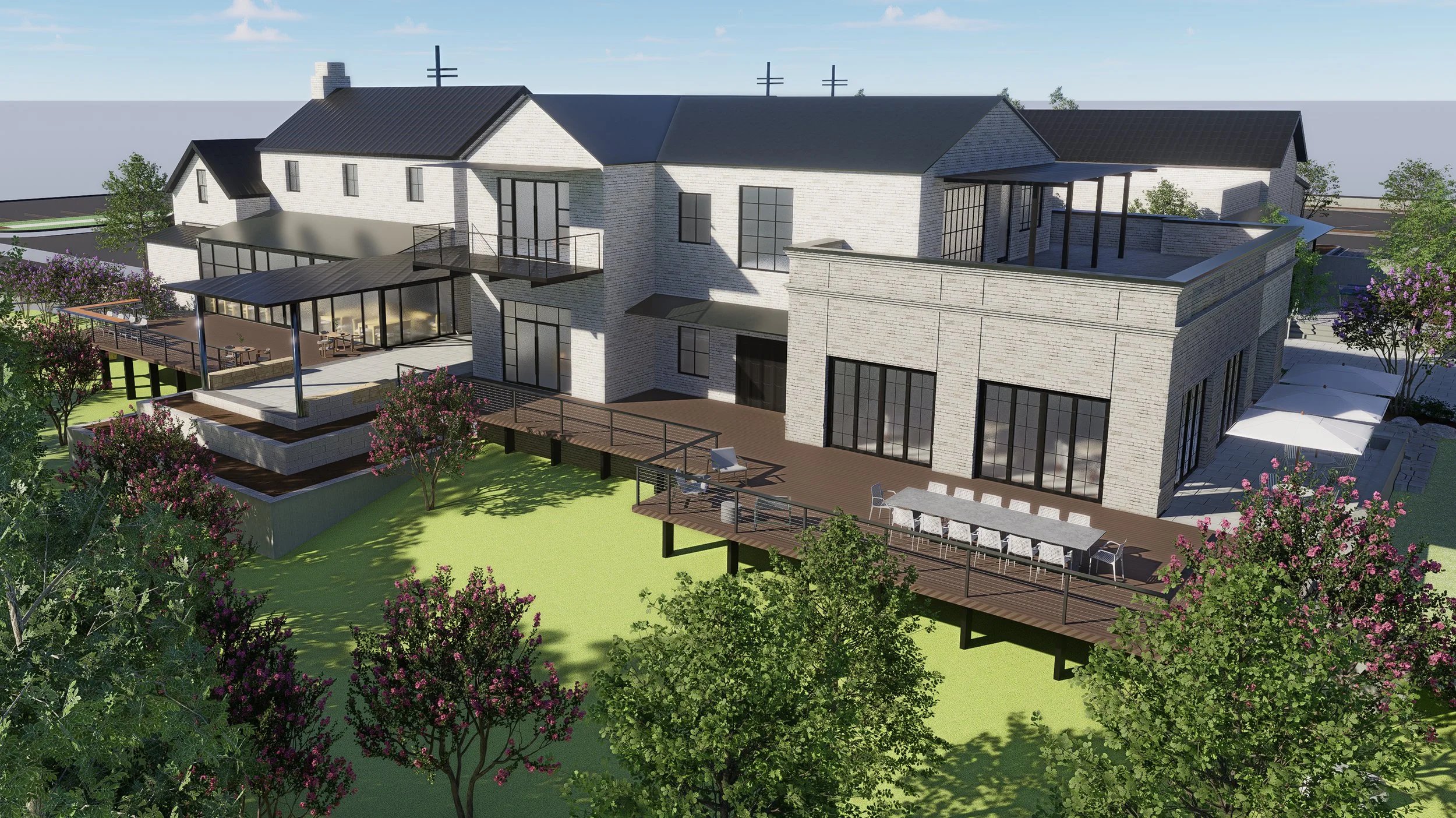 A modern multi-story house with a large deck and outdoor seating area, surrounded by trees and flowering plants.