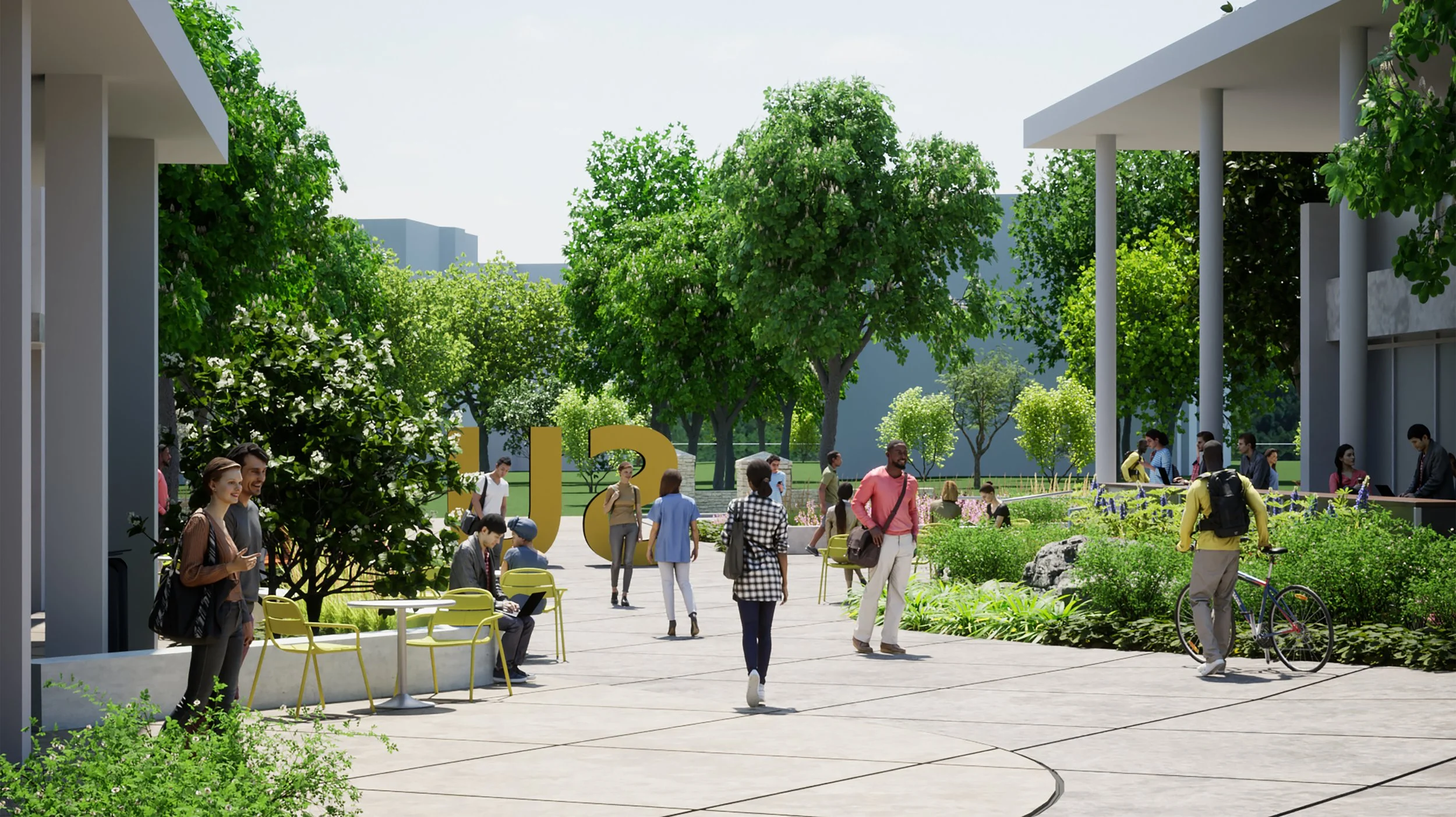 People walking, sitting, and talking in a university campus courtyard with green trees, modern buildings, and large yellow letters spelling 'U'.
