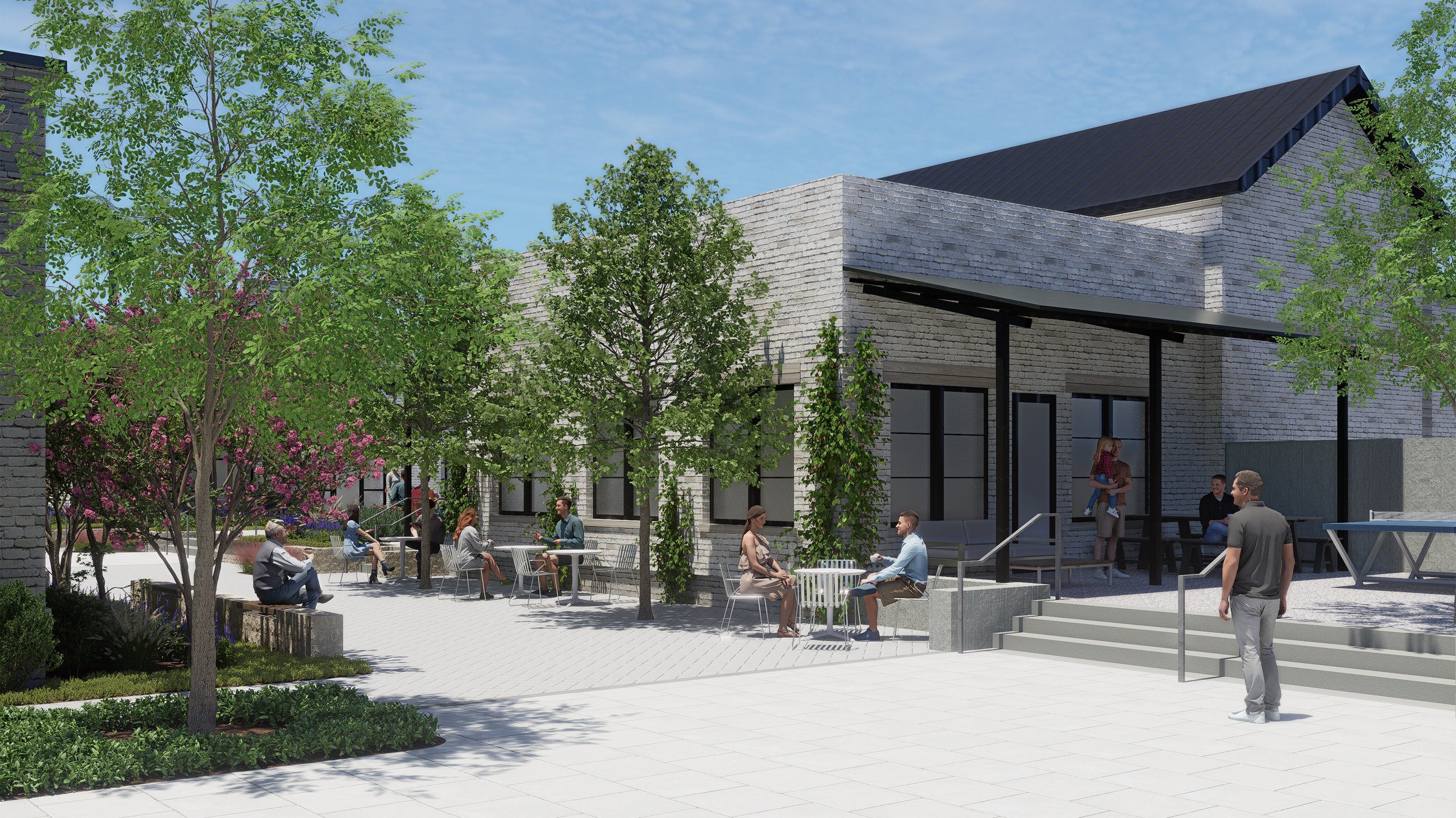 An outdoor courtyard with trees, shrubs, and people sitting and chatting near a modern building with brick walls and large windows.