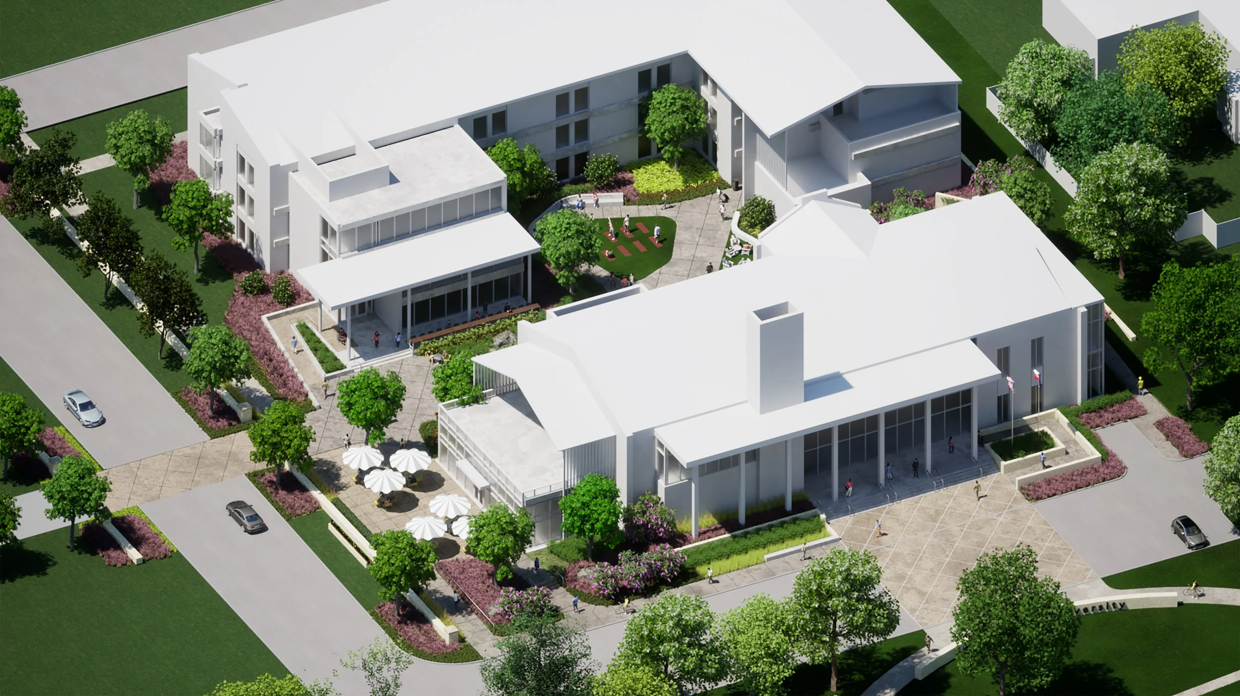 Aerial view of a modern residential or commercial complex with multiple white buildings, landscaped gardens, trees, walkways, and outdoor seating areas, including shaded tables with umbrellas.