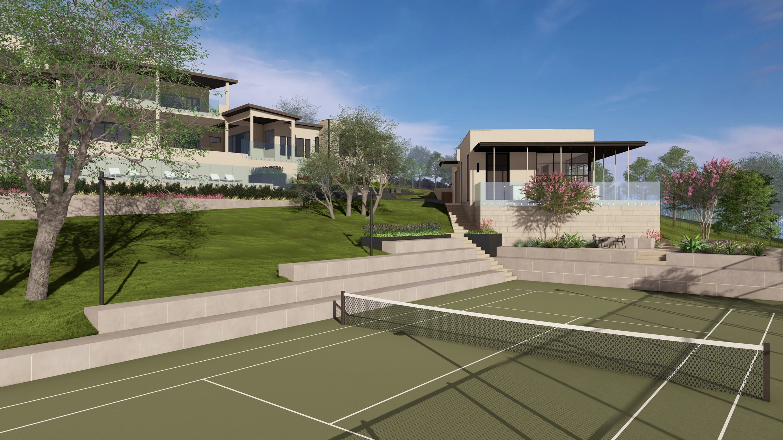 A modern tennis court area with a net and court markings, surrounded by landscaped tiered steps and seating. In the background, there are contemporary buildings and lush trees under a blue sky.