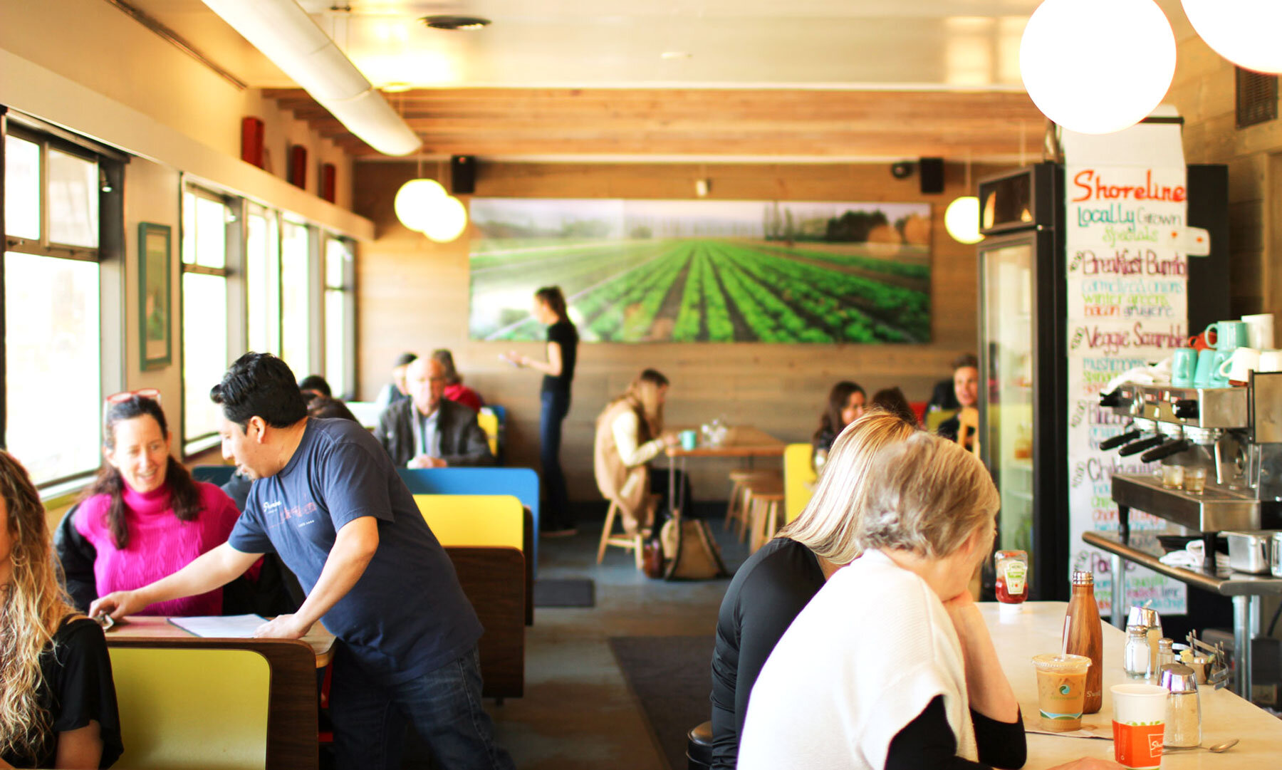 An interior photo of patrons sitting at tables inside the Shoreline Coffee Shop