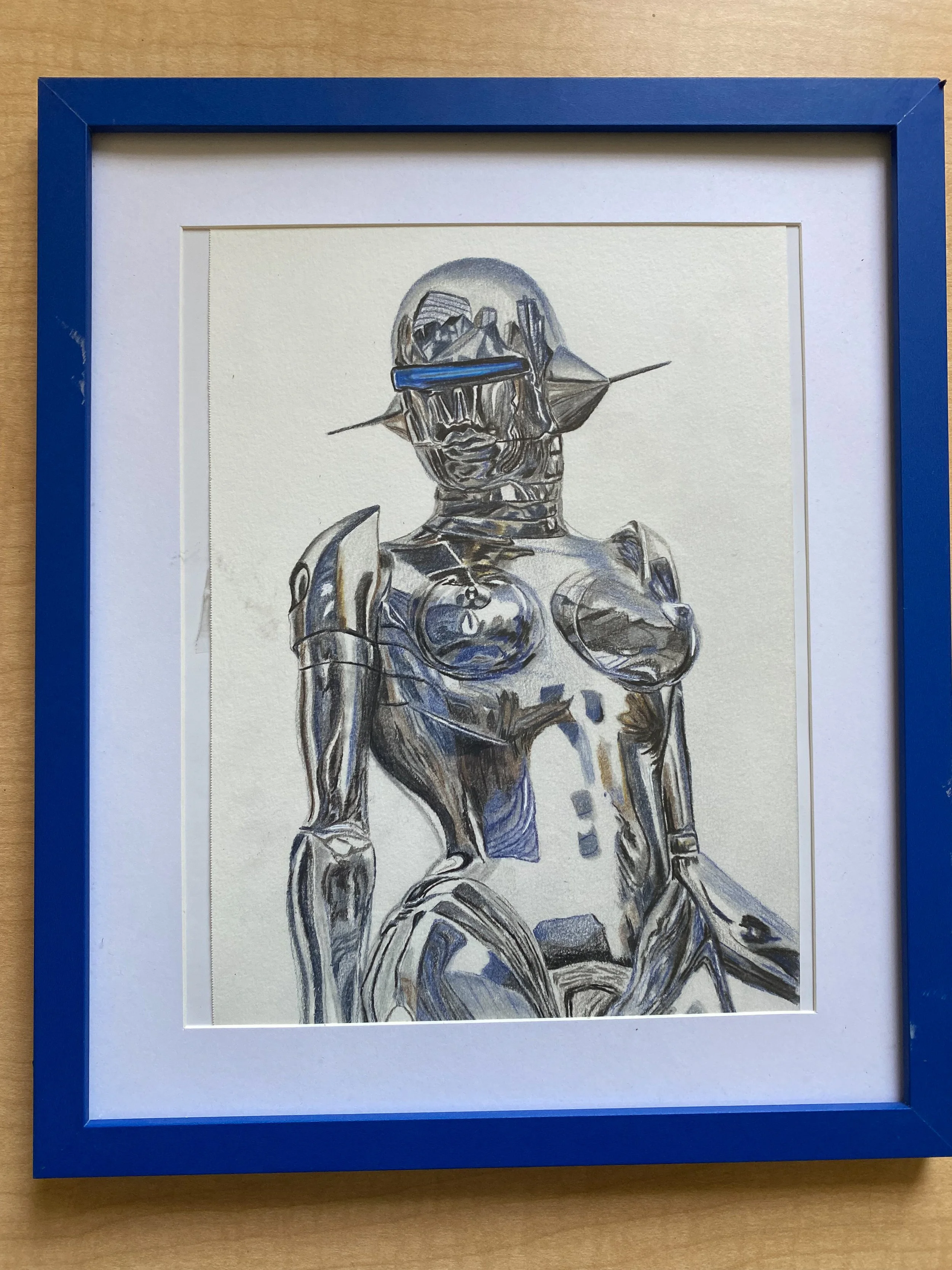 A framed artwork of a futuristic female robotic figure with metallic surfaces and a helmet-like headgear with a blue visor, set against a plain background.