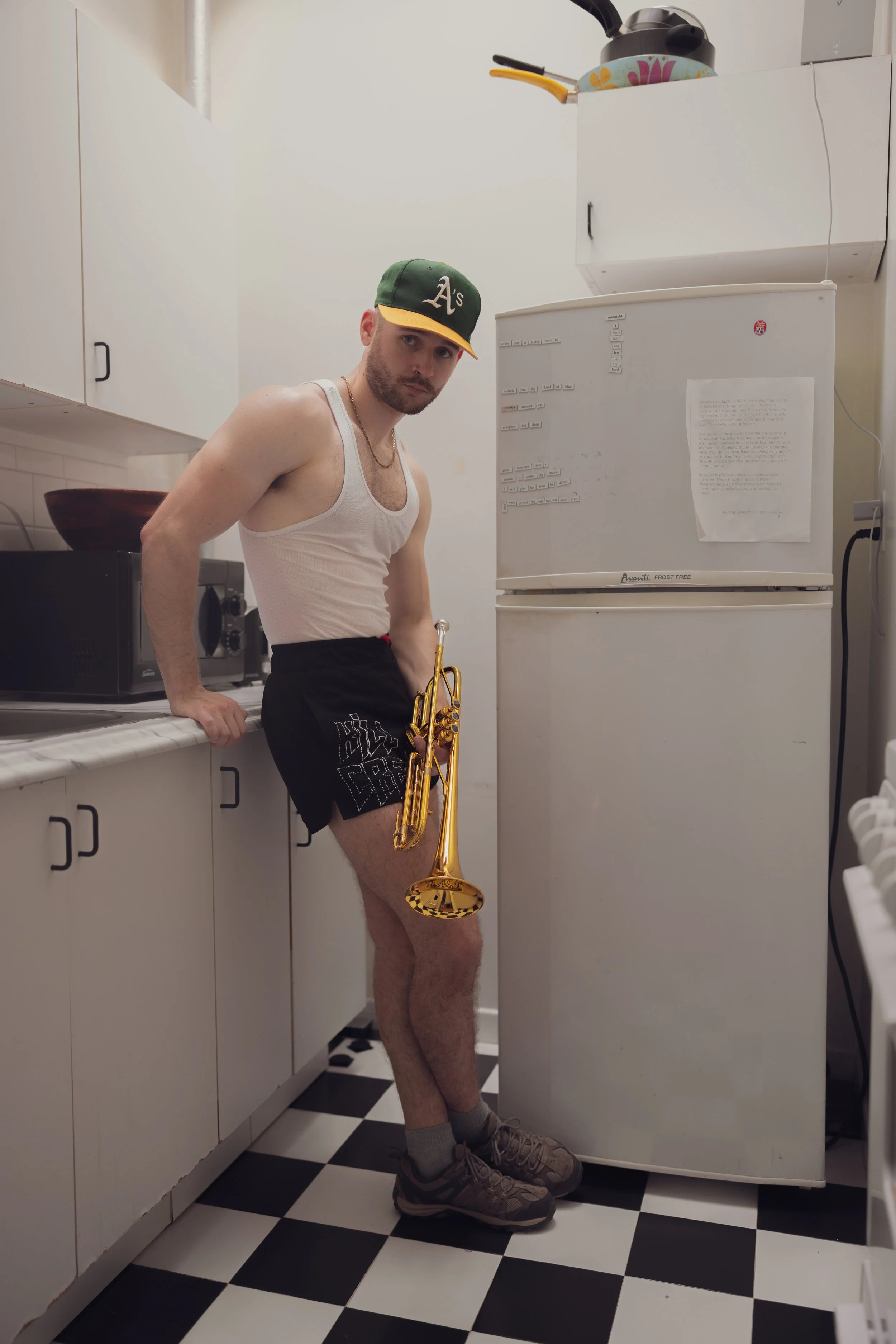 Austin Simmons in his kitchen holding a trumpet