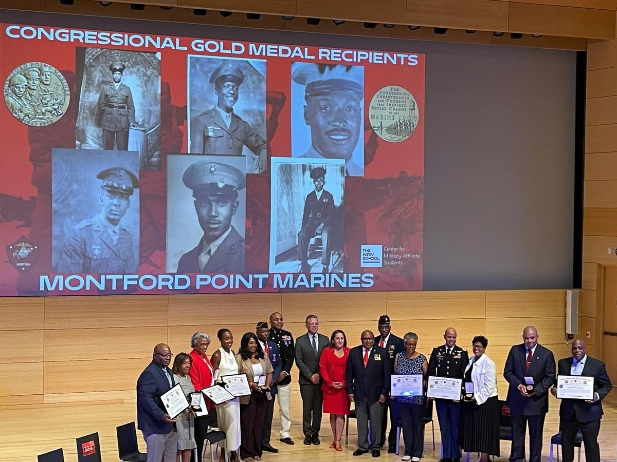 Families, Marines and guests on stage at The New School's Tishman Auditorium beneath a screen honoring the Montford Point Marines Congressional Gold Medal recipients