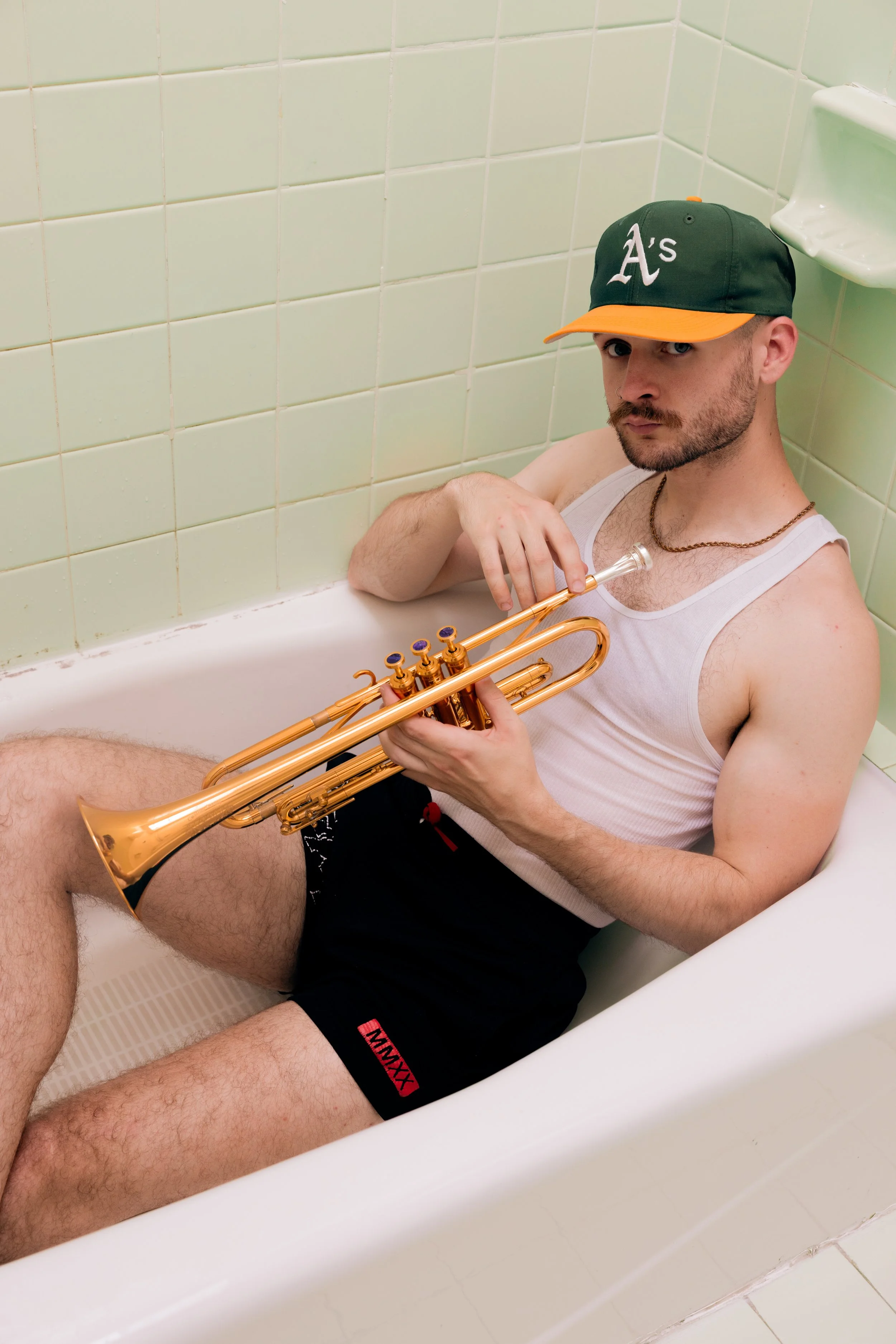 Austin Simmons sitting in a bathtub holding a trumpet