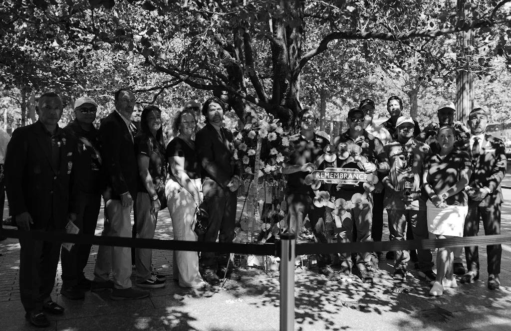 Veterans and guests with a Remembrance wreath at the Survivor Tree during a wreath laying ceremony at the 9/11 Memorial
