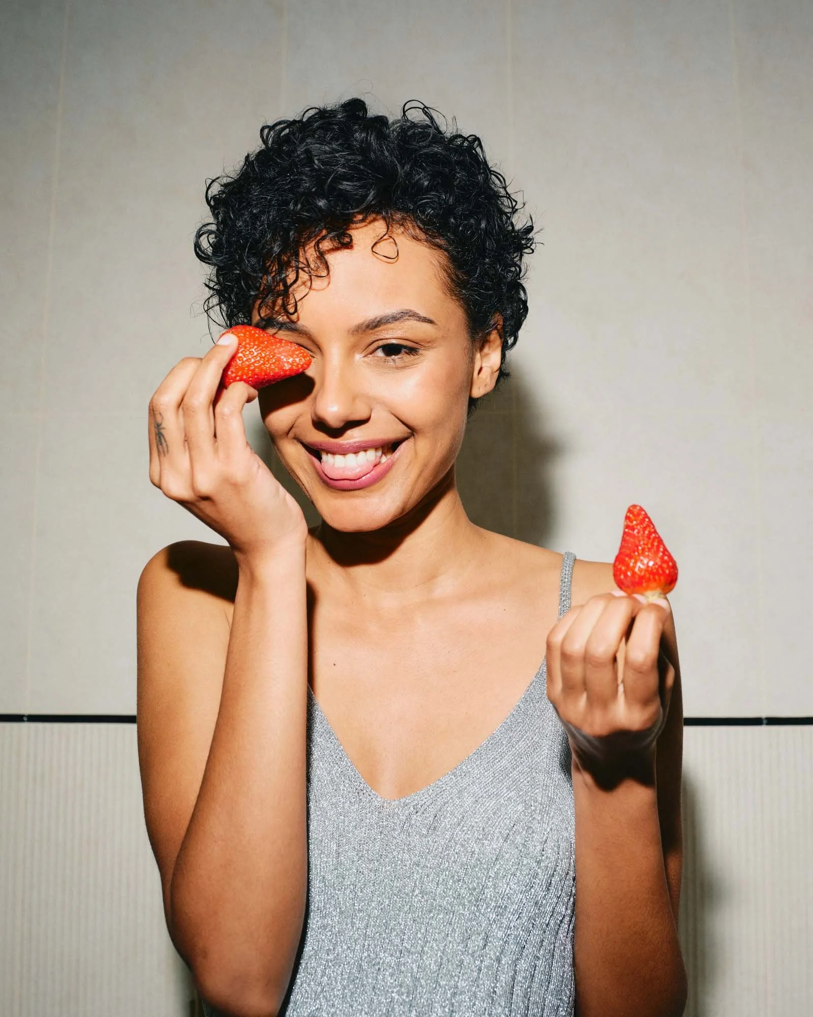 Woman with accessible reproductive healthcare and insurance-covered OB/GYN services at Maryam smiling while holding strawberries.