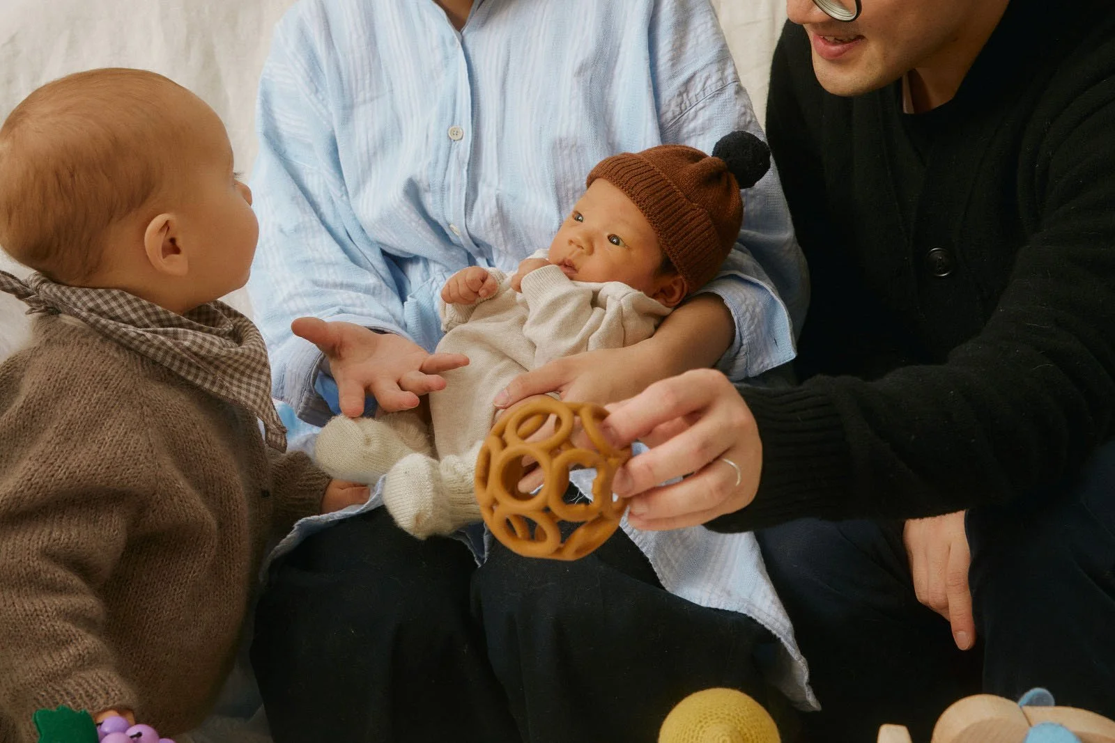 Parents holding a newborn while another child looks on, reflecting compassionate pregnancy, postpartum, and family-centered reproductive healthcare at Maryam Reproductive Health + Wellness.