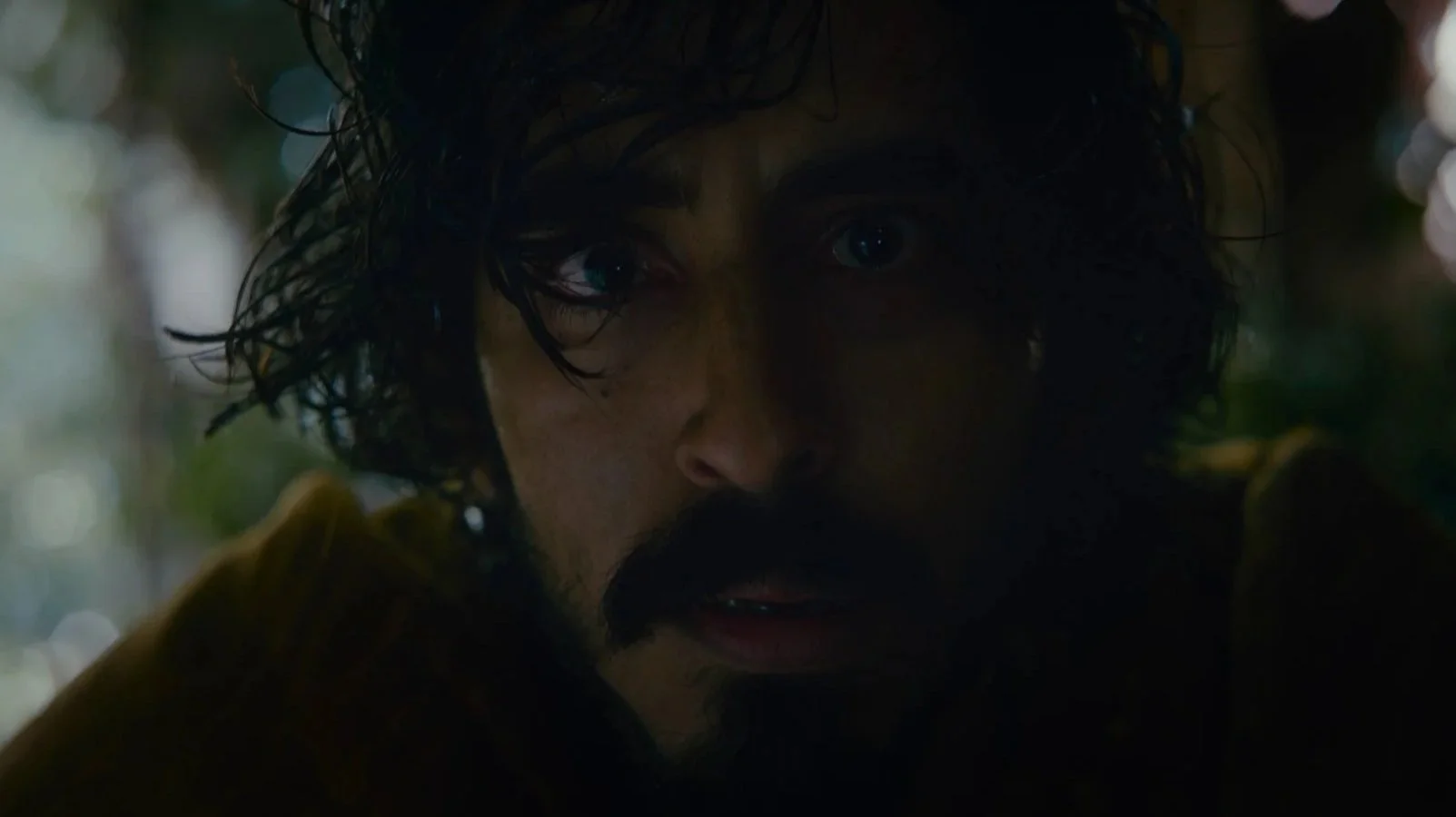 Still from The Green Knight showing a close-up of a man's face