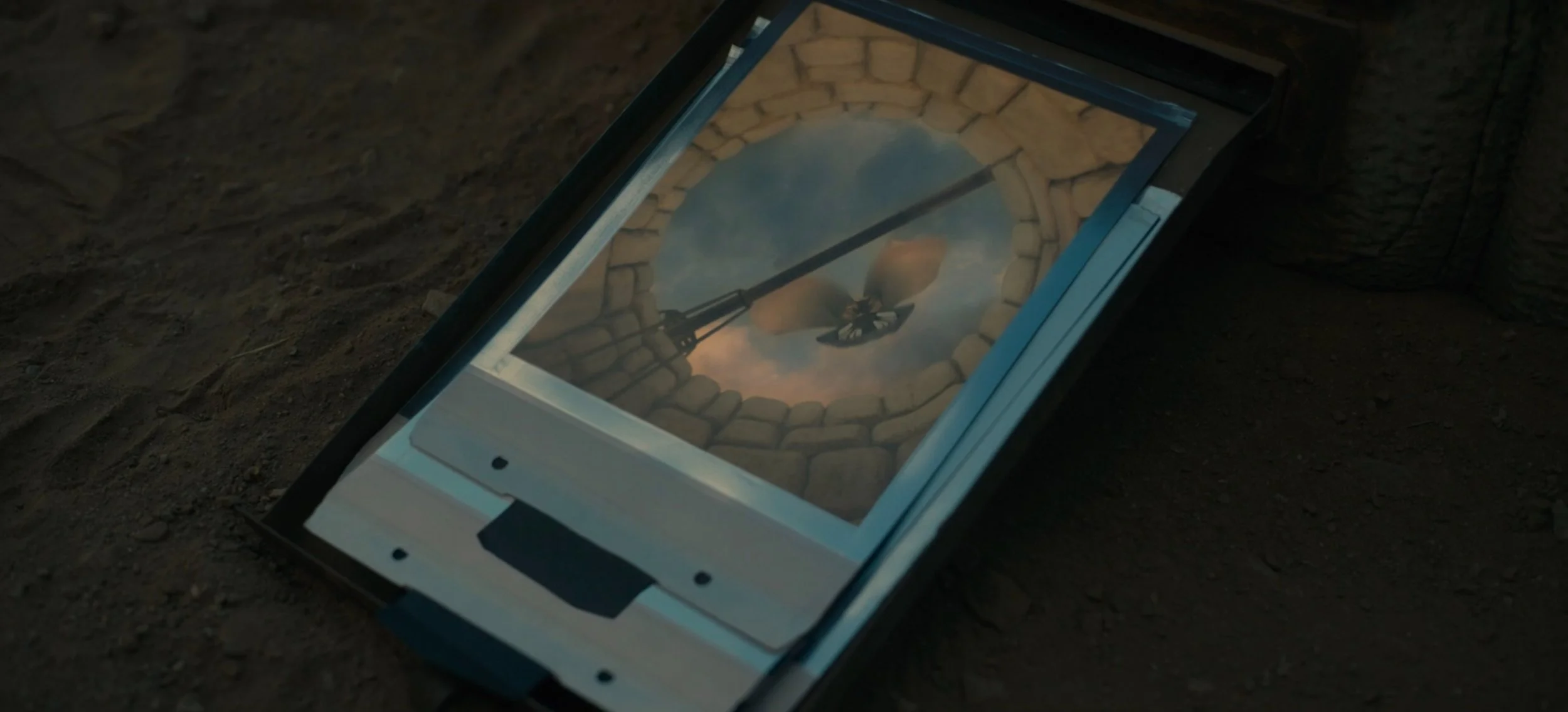 Still from Nope (2022) showing a polaroid style photo of an alien from the point of view of a wishing well