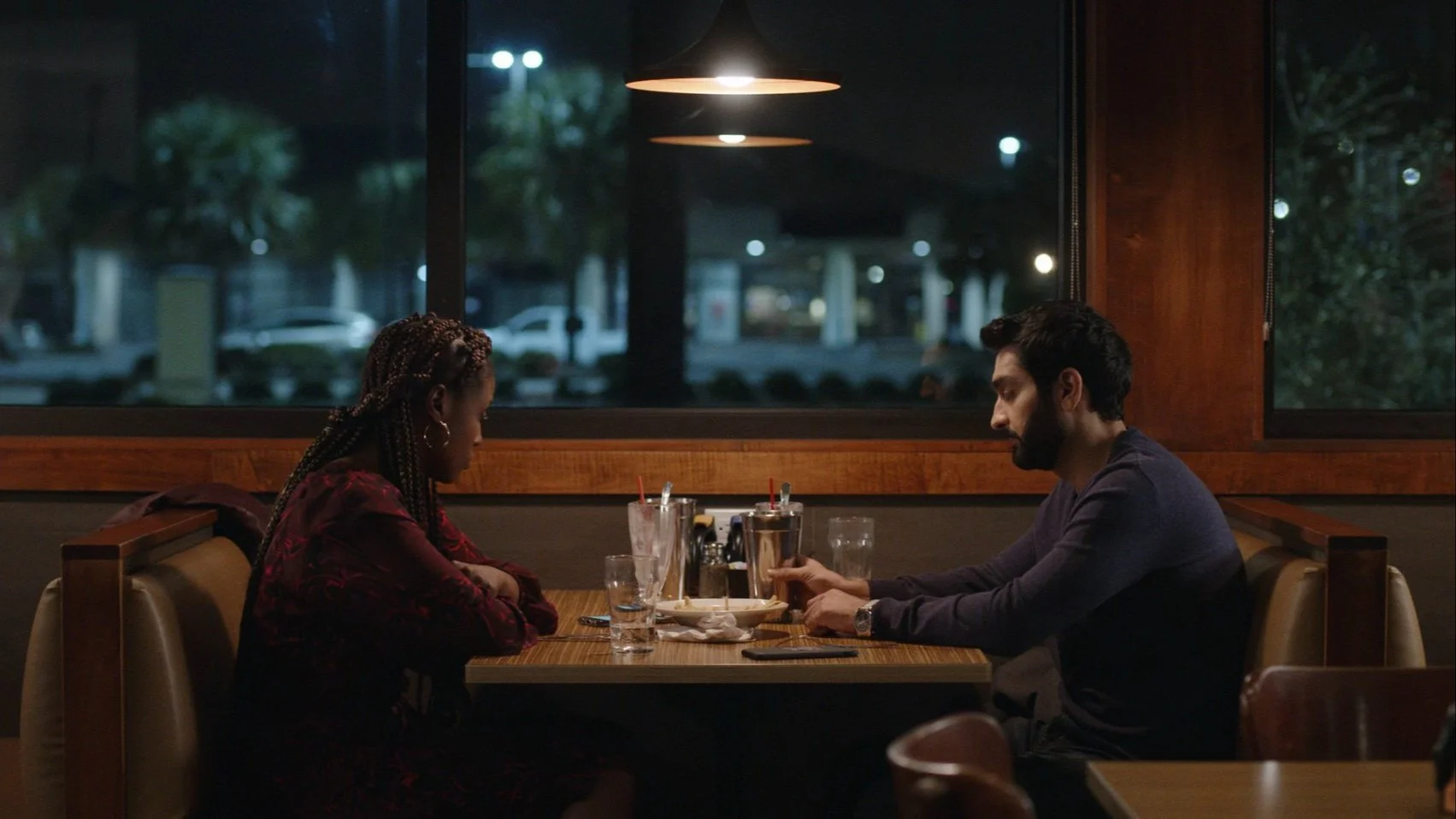 Still from The Lovebirds (2020) with a man and woman sitting across from each other in a diner booth