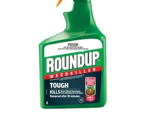 A green spray bottle of Roundup weed killer with a white, red, and black label indicating it is toxic and designed to kill weeds, including roots.