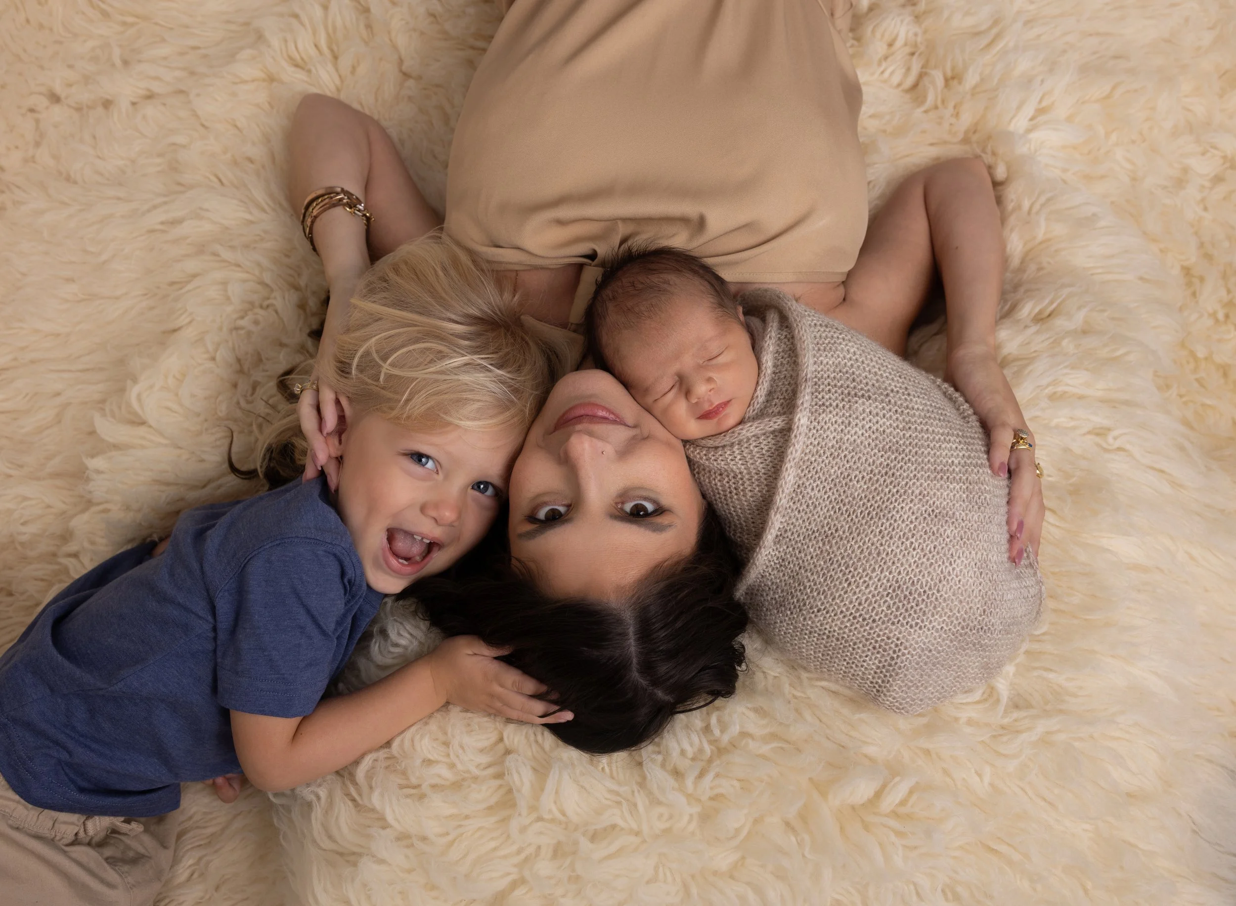 Mom, brother, and newborn on flokati in North Port FL photo studio