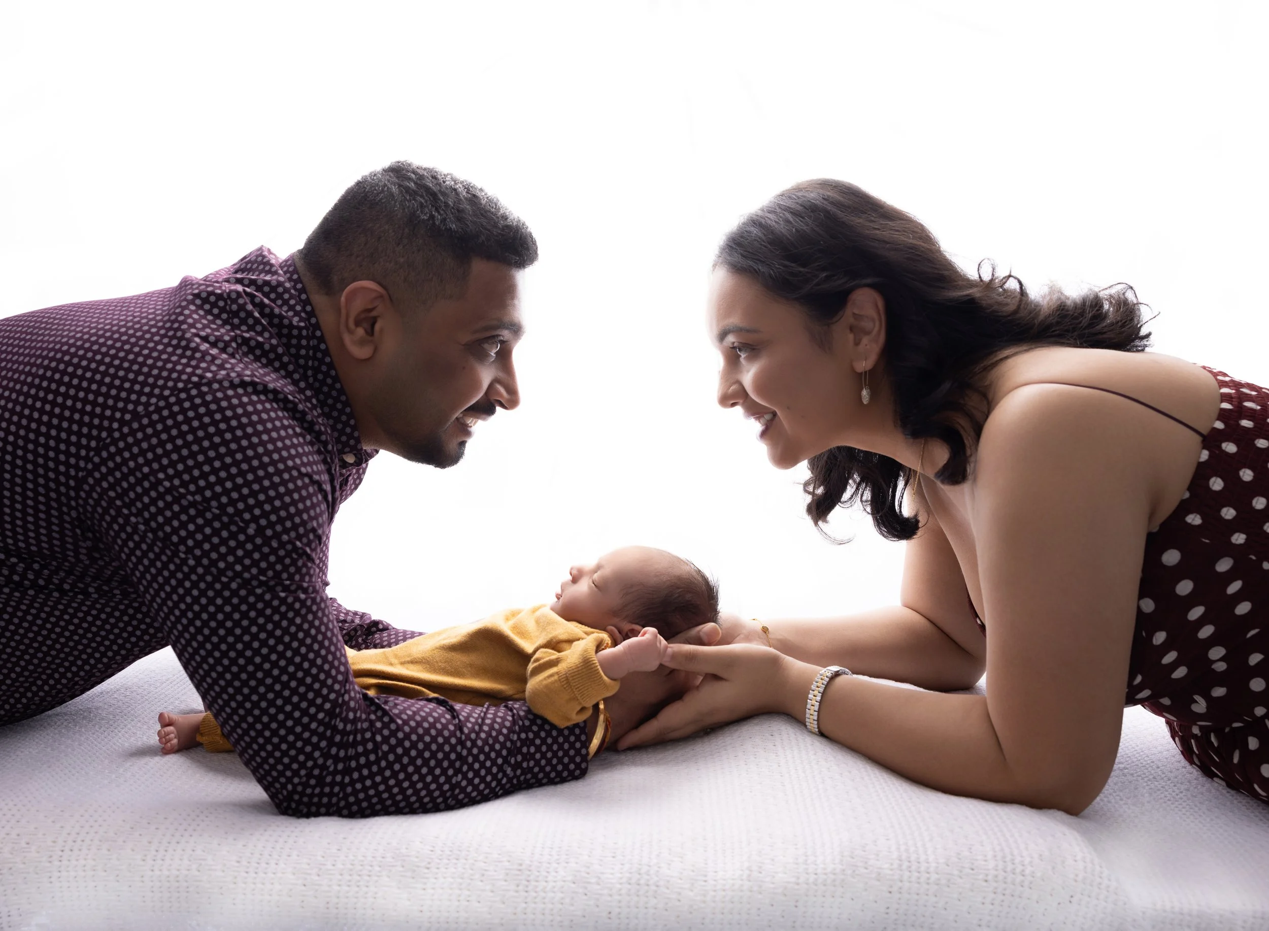 Mom, dad, and newborn baby boy on white backlit backdrop in North Port FL.