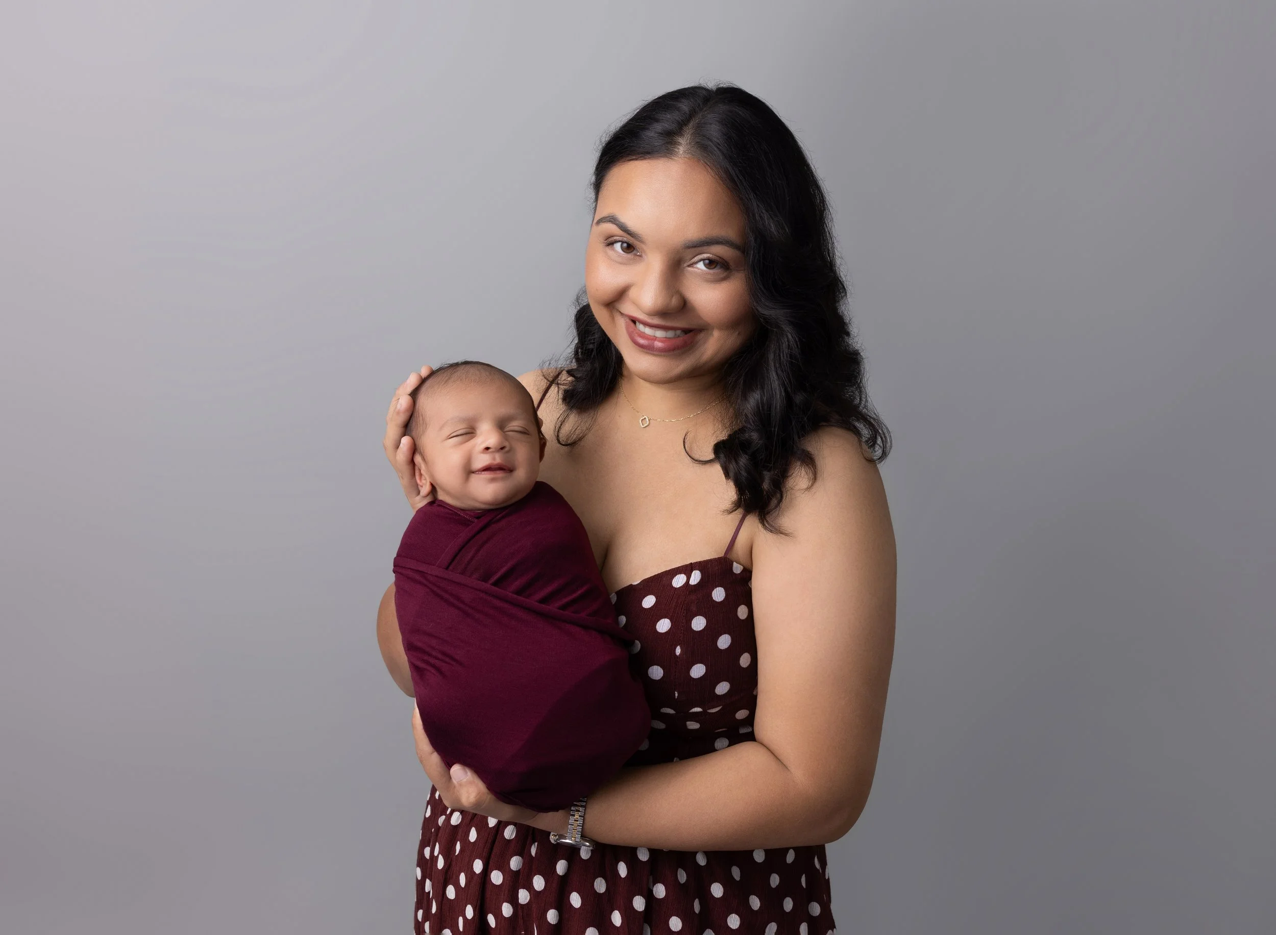Mom and baby in burgundy with baby boy smiling in Sarasota FL photo studio.