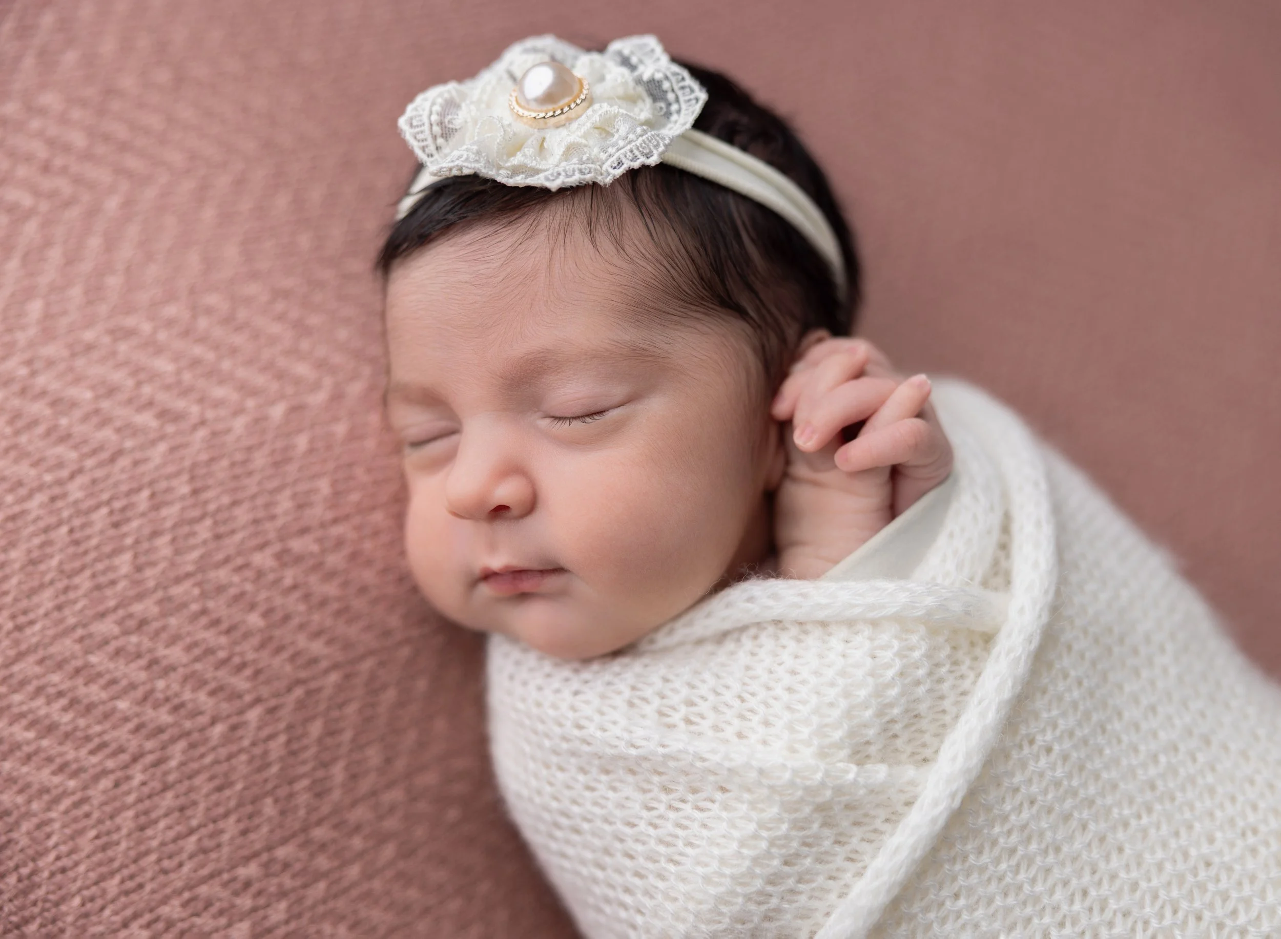 Newborn girl in cream wrap with clasped hands North Port 