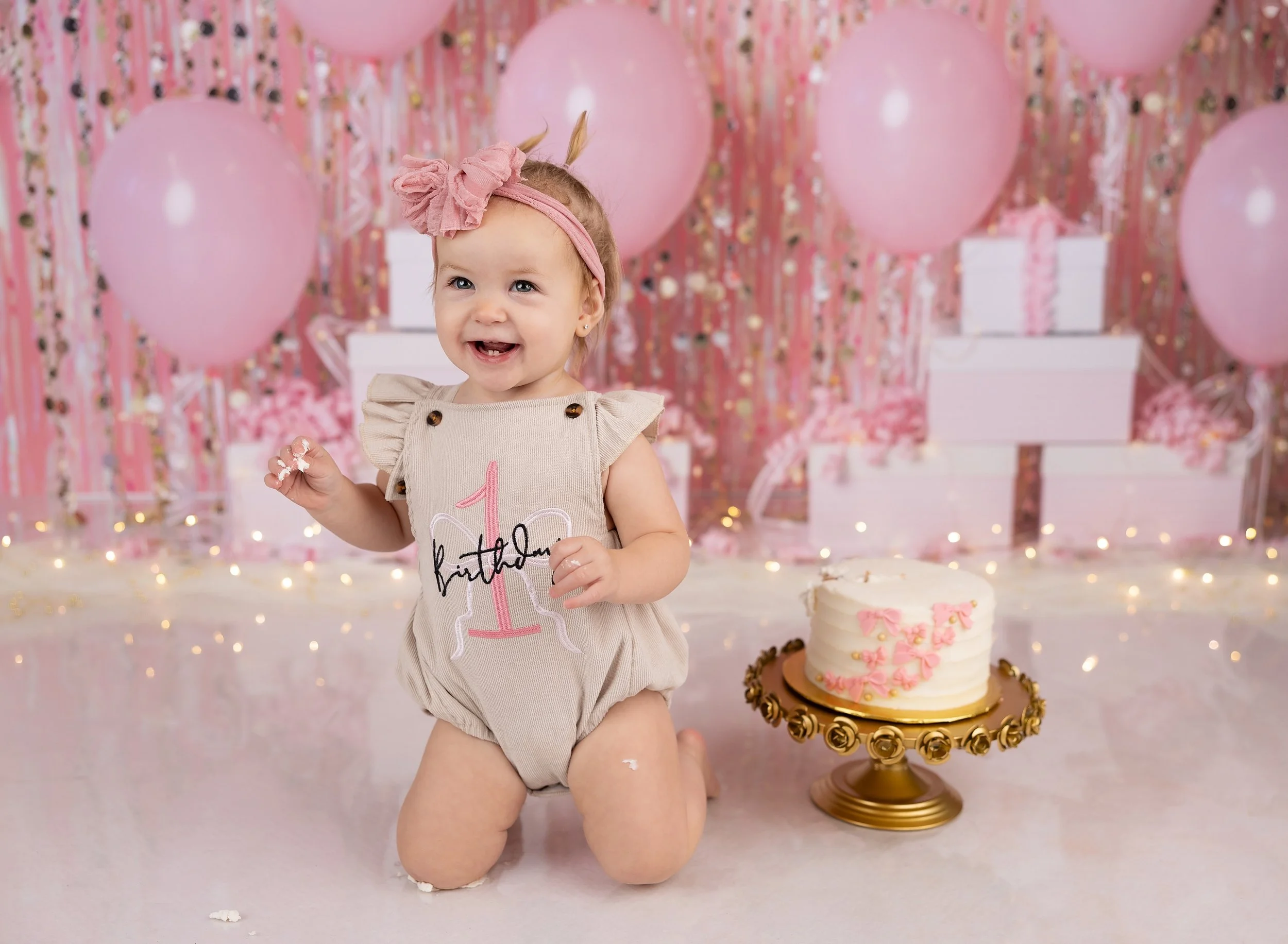 First birthday cake smash with pink gifts and balloons in Port Charlotte, FL photo studio