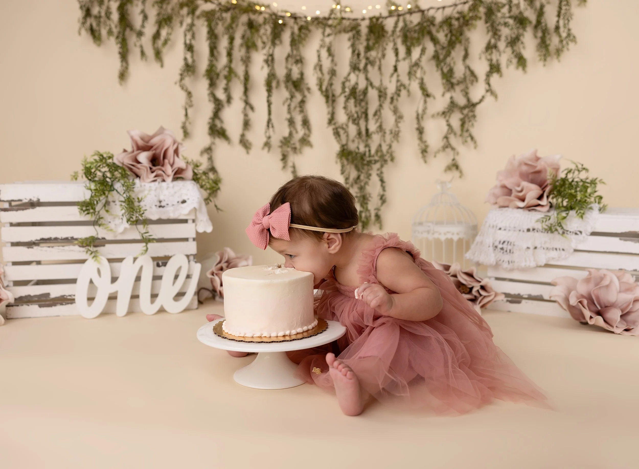 First birthday photo session on floral backdrop eating cake North Port, FL