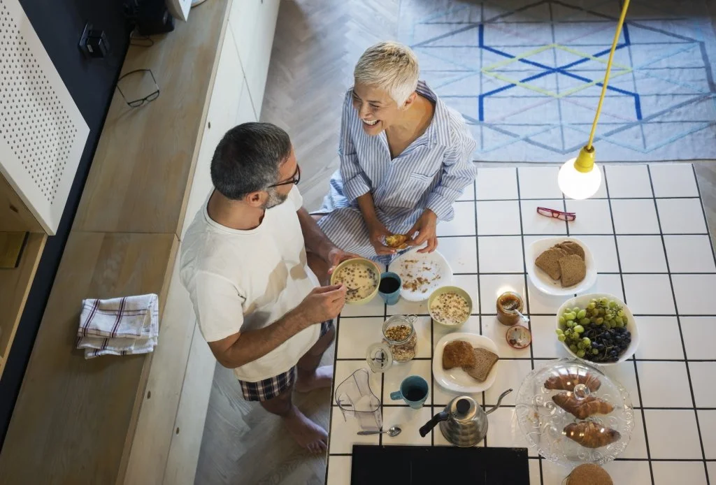 Couple sharing a fun moment while they eat breakfast after a session of couples counseling