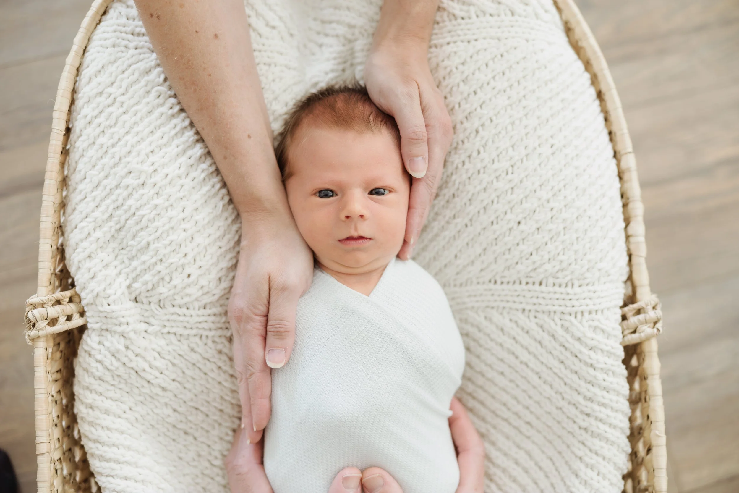 In-home lifestyle newborn photography in Northern Massachusetts capturing a swaddled baby in soft morning light