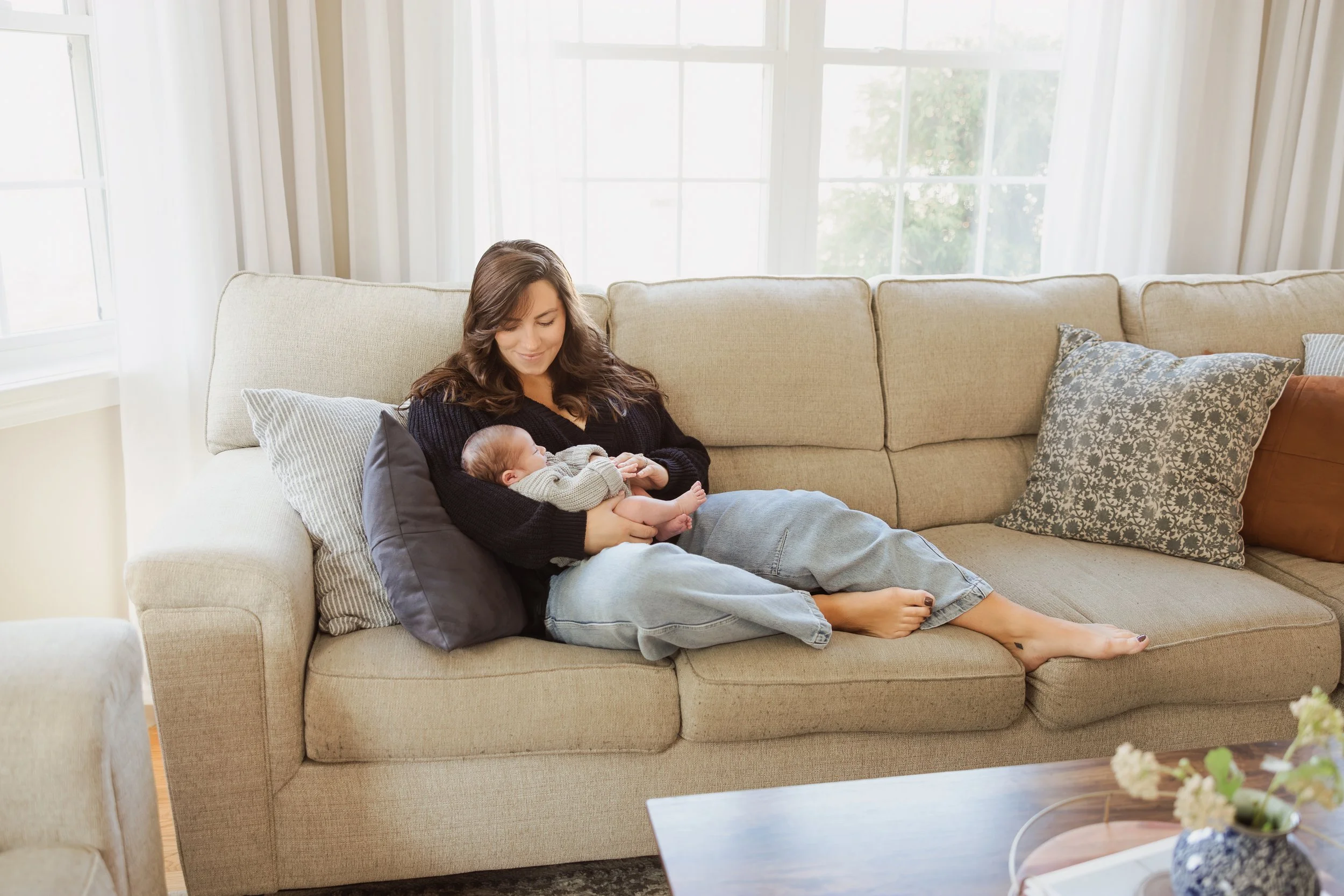Relaxed mom laughing during in-home lifestyle family session in Southern New Hampshire.
